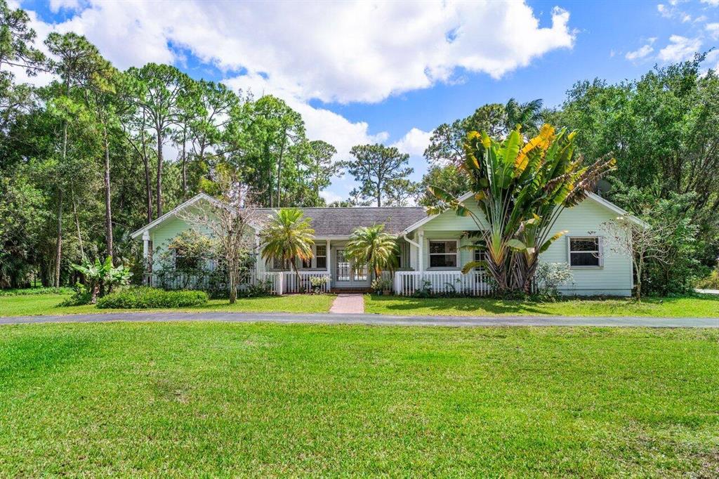 The possibilities are endless on this charming single family home with over 2,500 sq ft located on a sprawling 2 acres in Loxahatchee Groves.  Situated on a paved road just minutes to Wellington and Royal Palm Beach! Offering a split floor plan, renovated kitchen, upgraded lighting, high ceilings and a heated swimming pool, take advantage of the opportunity to transform this home into the modern farmhouse or equestrian property you've always dreamed of.The entire property is fenced with a 22 x 33 workshop.