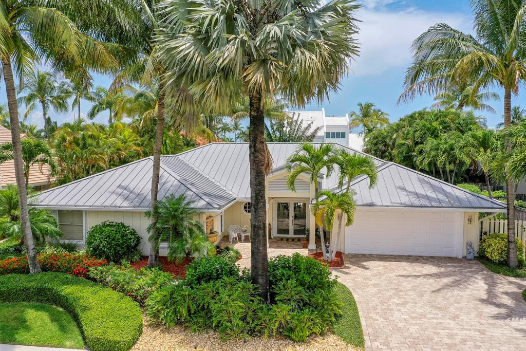 This is the epitome of Key West style in the premier seaside community of Olympus with large lots, and no zero lot lines. Located just eight homes away from private deeded beach access and minutes from the best restaurants and retail Jupiter has to offer. The backyard is a tropical paradise with resort style heated pool, covered lanai, gas-fed tiki torches and blue-glass fire pit - on a quiet day you can hear the waves crashing. Enter the front door into the sun-filled living room that lures you to the backyard pool area through French doors. To the left is the spacious open concept kitchen, dining, family room with multiple sky lights that flood the rooms with sunlight and looks out to the backyard. To the right is the spacious private primary suite decorated with plantation shutters,