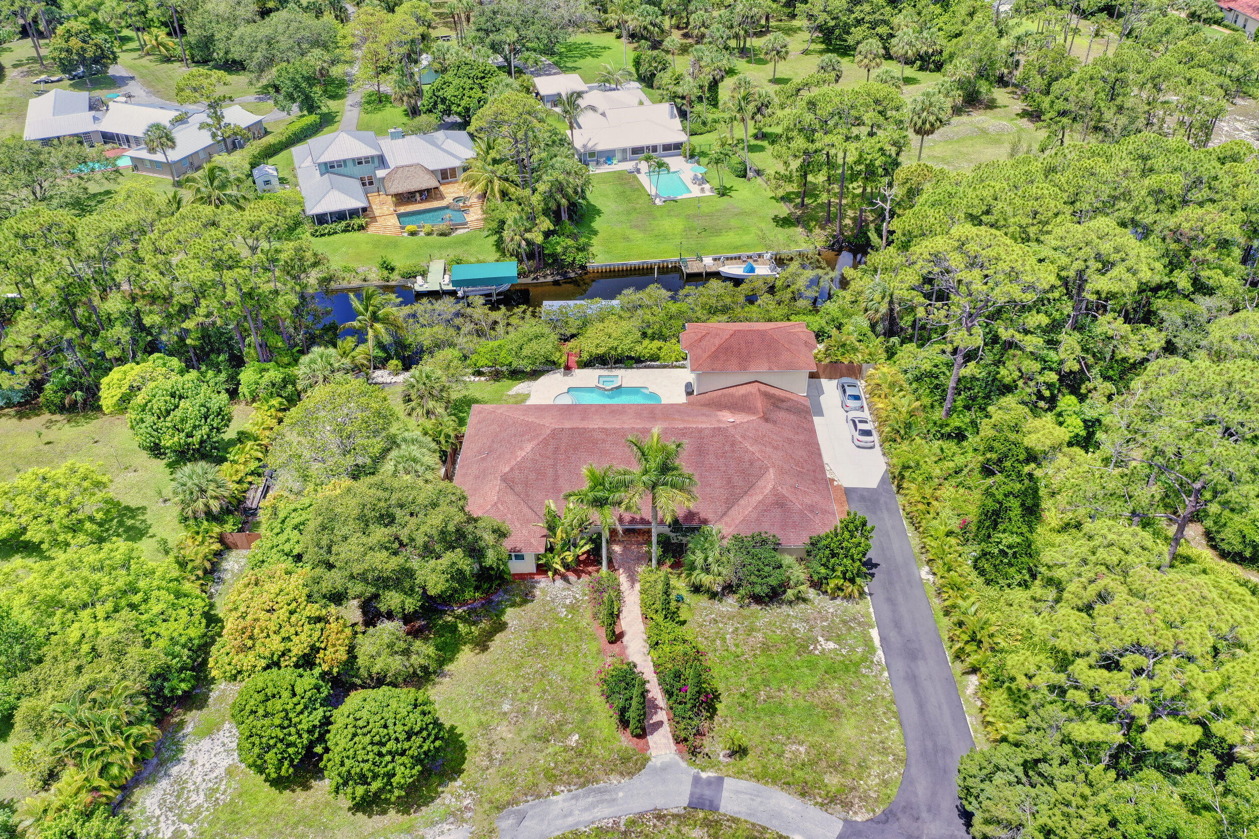 WATERFRONT (193 Ft); Over 5,000 living Sq ft house on 2.5 Acres in Jupiter, East of I-95. Rare Paradise; Spacious home featuring 7 extra-large bedrooms equipped with ensuites for each and walk-in closets. Floor plan is perfect for entertaining with multiple outlets to host all your guests with an oversized patio, pool, and hot tub right on the water with ocean access. Impact windows & doors. Just off of Loxahatchee Rd and next to Jonathan Dickinson State Park with over 11,500 aces of hiking trails right outside your double gated entrance. The gate is equipped with an emergency S.O.S feature for emergency vehicles with keyless entry for family/guests by cell phone with camera viewing. NO HOA!