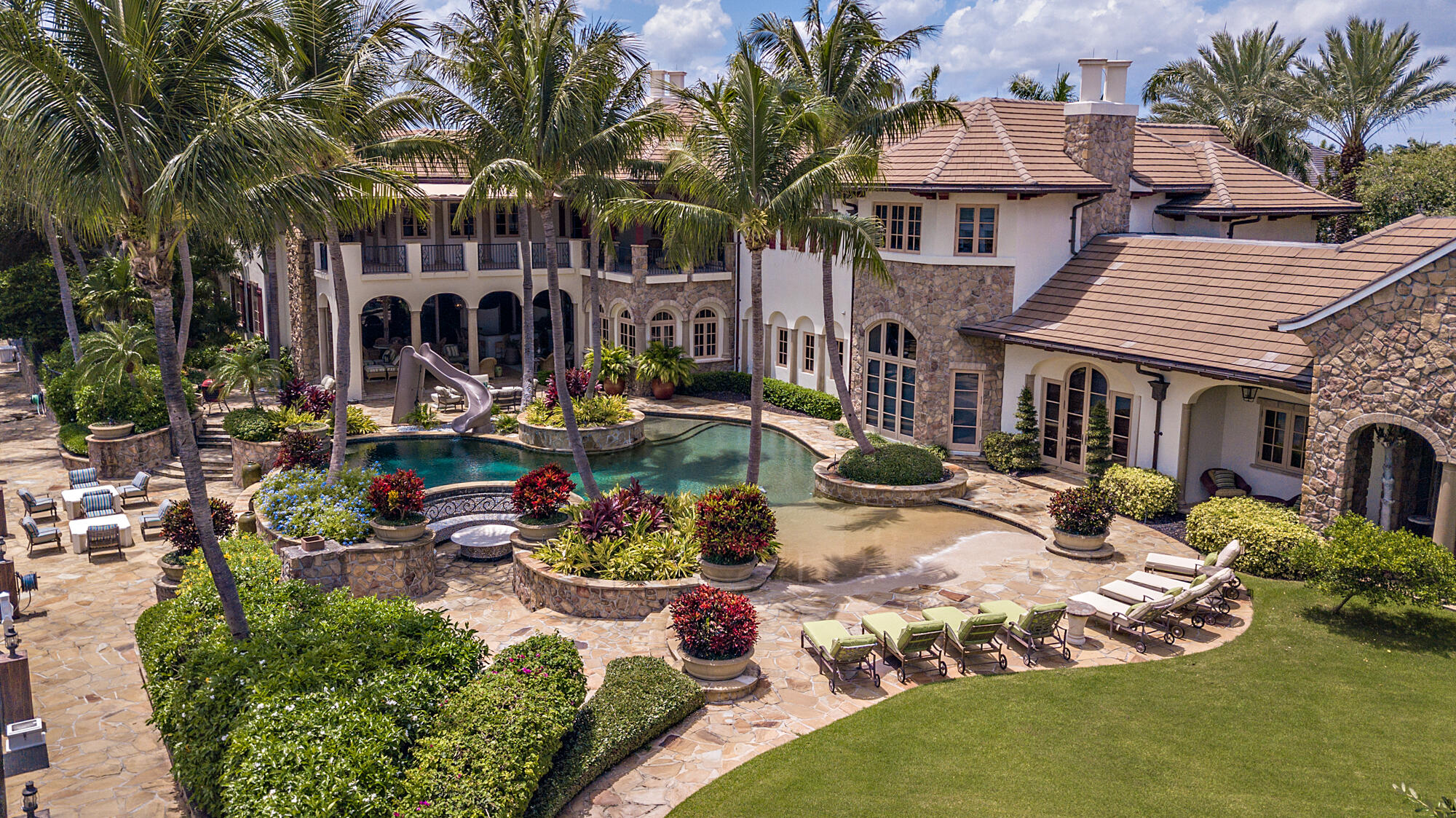 This unprecedented 25-room mansion sits on over one acre with 300 feet of water frontage.  This property has been said to be one of the most celebrated estates in the Royal Palm Yacht & Country Club. Luxurious living with over 18,000sf of expansive living areas, formal dining room, temperature-controlled wine cellar, movie theater, game rooms, stunning flagstone terraces, a resort-style pool, and grand entertainment loggia. Perfectly situated on a triple lot complete with 6 car garage and dock for over 200' yacht.