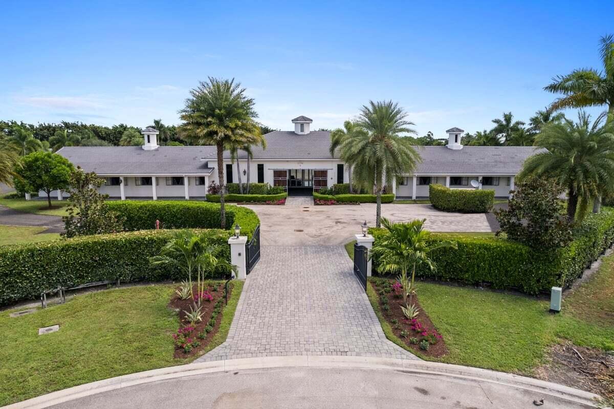 WELCOME TO SHUTTERFLY WAY.  Ideally located in Grand Prix Village South, ''Wellington's Oceanfront''.  This 8.4-acre property features a Loddon Equestrian, Ltd. 20-stall Grand Prix Stable, designed in the UK and constructed on-site. The property stands alone on Shutterfly Way at the end of a nicely appointed circular brick paver cul-de-sac, gated entry, totally private, secure, no traffic. Short hack to WEF show grounds. All architectural hardware shipped from England, steel double-hang windows with u-shape grates and matching gray powder coat stalls and teak work.  A forepart brick paver catwalk to Henderson sliding door open to a magnificent bright interior which boasts 3-glass roof battlements for natural light rubber pavers through-out, tall natural wood arched ceilings, recessed lighting.  Center of the building is a modern owners gallery with 2-retractable glass walls, full bath, full chef's kitchen with custom cabinetry, granite tops, high-end appliances, furniture included. Gallery is flanked by two wings respectively, with central fan system, central fire-sprinkler system, a/c grooms kitchen, 2-a/c feed/hay rooms, 2-wood panel tack rooms, 4-wash stalls, 2-bathrooms. Matching 2/2 cottage with fire-sprinkler system, large gathering room, front patio, 2-car garage.  Never commercially used, the barn and cottage sit as nearly new. Buildings situated for spectacular sunrises/sets. Landscape Architect designed 8-paddocks, irrigation, massive bermuda Derby field which is also permitted by the town of Wellington for a covered arena, large jumping ring off owners viewing gallery, outdoor entertainment area with grill, refrigerator and fireplace.  Property abuts riding trails. Appointment only, Call agent.