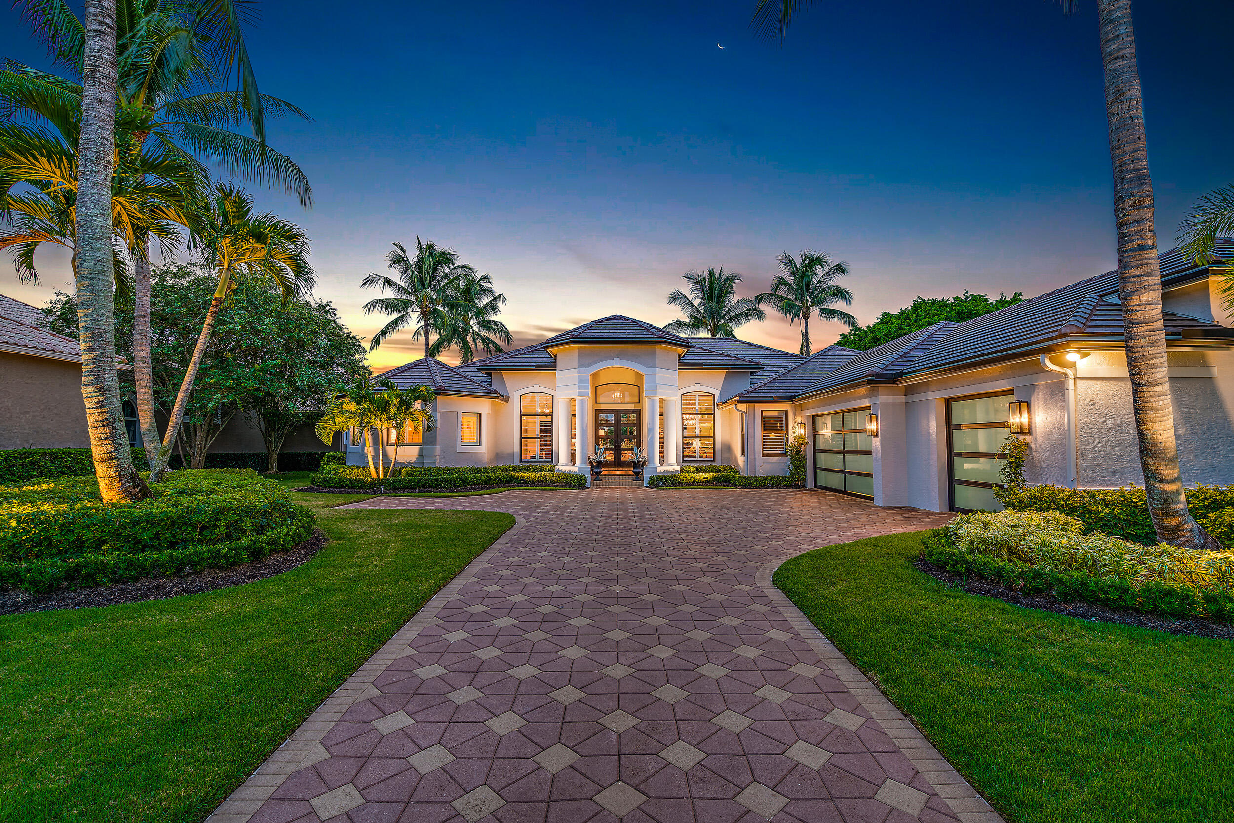 Spectacularly renovated inside and out, designer-done, and located on a unique lot on Ibis's 'Street of Dreams,' this re-imagined estate is one of the closest estate homes in Ibis to the Club. Simply walk, bike, or take a quick golf cart ride to the Club through a cart-path short-cut, designed for the exclusive usage of residents of this area. Sleek and modern, yet warm and inviting, this 2022-renovated home boasts a NEW ROOF + NEW GUTTERS, NEW IMPACT GLASS throughout, NEW designer Impact Glass + Mahogany FRONT DOORS, and NEW Impact Glass and steel GARAGE DOORS --all done in 2022. The landscaping has been thoughtfully redesigned in a stately and manicured way that provides magnificent curb appeal, and works cohesively with the contemporized exterior.