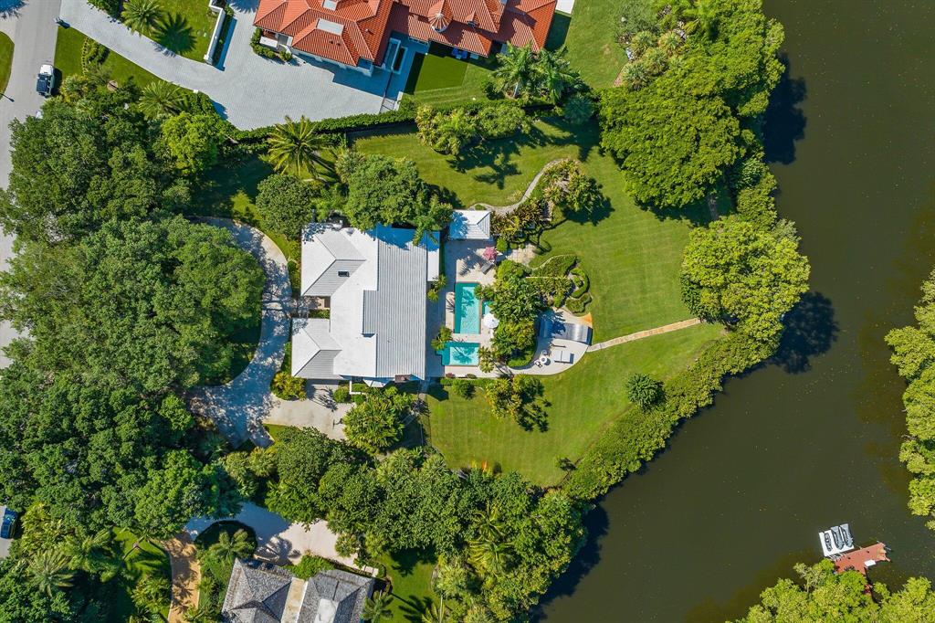Rare 1.5 acres gem nestled in gated Seminole Landing.  Beautiful Banyan trees on water with boat access.  This 4 bedroom, 3.5 bath home features a private dock, lush tropical landscaping, pool and spa.  Intracoastal/Ocean access, 25 min to airport, 25 min to Palm Beach.