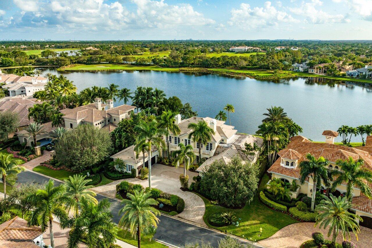 Magnificent, one-of-a-kind, nearly 8,000 square foot Bermuda style custom estate in the prestigious Palacio community of Mirasol, offers long and wide lake views, 6 bedrooms, 7 full baths, 2 half baths, a private theater, wine cellar, elevator and custom his and her office. A spacious motor court with 3 car and golf cart garages leads to a grand entrance through double wood doors. Enter into luxury and elegance, expressed through marble flooring with onyx inlays and a wood and wrought iron circular staircase. A custom fireplace, crown moldings, exceptional ceiling detail, millwork and lighting fixtures are masterfully placed throughout for exquisite architectural detail. Gourmet kitchen fit for professionals, with 6 burner gas range, 3 ovens, vegetable sink with refrigerator drawers in center island and top of the line appliances, including 2 dishwashers. A wood beamed ceiling, rich granite counter tops and counter seating complete this special room. The elegant dining room has artistic ceiling detail, columns and a beautifully designed onyx patterned floor. Relax in custom family room with deep toned wood ceiling beaming and large matching built-in. The outdoors truly comes inside with a unique wall of hide-away pocket sliding doors. Beautiful office fully fitted in exquisite woods with exceptional shelving and built-ins. Private theatre with extensive detailed millwork has custom built-in entertainment systems and two-tiered flooring. Spectacular master bedroom with wet bar and microwave and his and hers walk-in closets with custom shelves and dressers. Exceptionally appointed his and her baths with over-sized frameless shower, whirlpool tub, dual vanities and custom cabinetry. An adjoining sitting room or second office, also with beautiful cabinetry, has doors leading to the patio and pool to complete this expansive master suite. A private, luxurious guest bedroom and bath with morning kitchen can also be found on the main level. Ascend the beautiful wooden staircase to the loft and 4 additional bedrooms, each with full baths, personal A/C zones and French doors to terraced balconies. Unparalleled outdoor area, with complete privacy provided by mature landscaping, a large covered loggia with full summer kitchen, exceptional architectural detail and large pool with Jacuzzi, make this estate an absolute must to see!