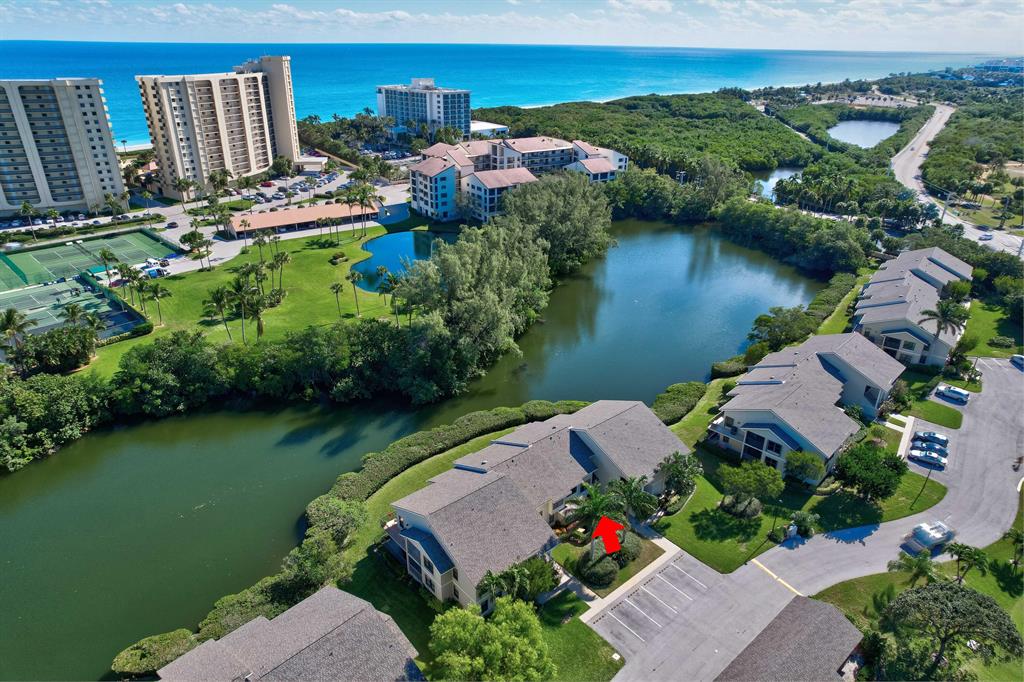The search is over!  The work is done!  Waterfront & golf course views on this completely renovated condo by the beach with over 1800+SF.  Enter this 2 story foyer & your jaw will drop.  Wood floors thru/out 1st & 2nd story plus staircase.  Customized white shaker kitchen cabinetry wi/quartz countertops. There is a laundry area, built in desk, pantry & GE Profile SS appliances.  Kitchen opens to LR/DR w/a wall of sliders leading to the screened in patio & open new wooden deck overlooking a salt water lagoon. BBQ ok here!  Half bath downstairs along w/extra storage under the stairs. 2nd Floor has oversized master suite w/custom cabinetry, floating shelves, walk in closet w/California closet. Master bathroom has seamless glass shower. Large guest suite has similar finishes. Carport w/storage