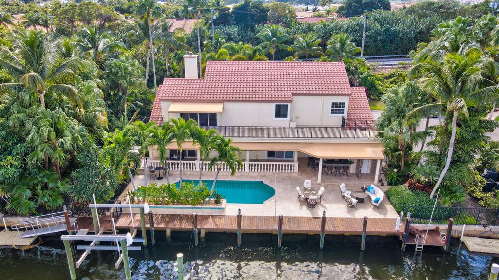 Boater's dream! Updated, move in ready home with 140'' of waterfrontage 1 lot off the point. 90'' dock, lift, jet ski pad, & paddle board /ramp/launch. Enormous backyard ideal for entertaining: heated pool & spa, cabana bath, expansive pool deck & lanai, & summer kitchen/bar. Gorgeous water views. Fantastic location for a quick cruise to the Boynton inlet & a few blocks walk to the beach, restaurants, shopping. Interior highlights include wood burning fireplace, marble & wood floors, vaulted ceilings, 120 bottle Liebherr wine fridge & Wolf gas range. Owner's suite features two spacious walk-in closets w/ built-ins, spa bathroom, and ICW view terrace that spans the length of the home.  FULL IMPACT WINDOWS & '22 WHOLE HOUSE GENERATOR. Deep 3 car garage with height for lifts. Paradise found!