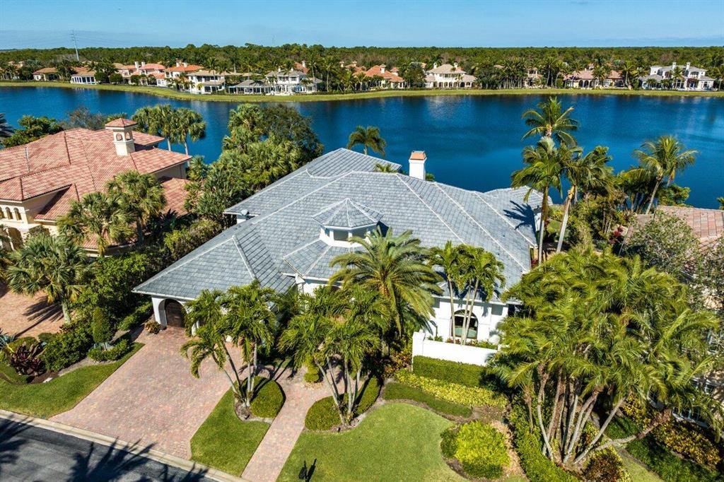 Stunning lake views for this light and bright custom estate home! Coveted golf membership and situated on a wide water lot in The Club at Mirasol. Step into the light and bright foyer that leads to the living room with gorgeous lake and pool views. This home offers over 5800 living square feet, 4bed/4.5 baths, office, and theater room all on one level. The redesigned gourmet kitchen boasts marble countertops, Miele appliances, built in coffee maker, Swarovski crystal hardware, wine fridge, and so much more. The backyard oasis is perfect for entertaining with summer kitchen, sparkling resort style flagstone pool & spa with water features, panoramic serene lake views, and more.