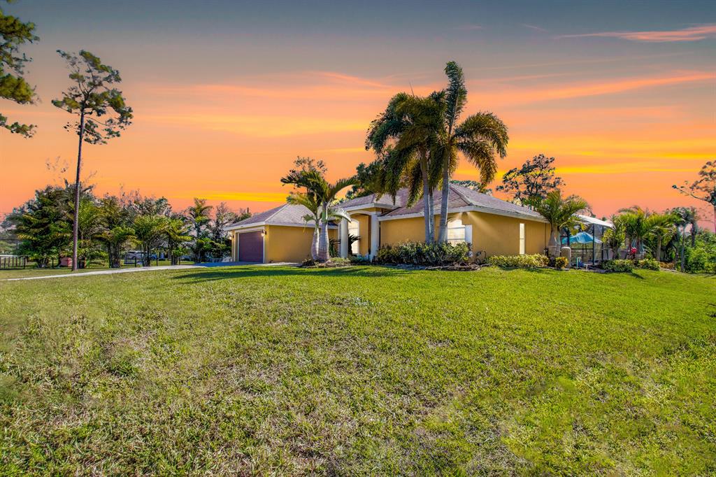 Welcome home to a truly private oasis! 1.25 cleared acres of land surround this stunning home. This 2384 total sq. ft. remodeled pool CBS home is high and dry! Loxahatchee living means peace, quiet, and no HOA. Bring your boat, cars, trucks, RV, golf cart, and 4 wheeler! This stunning 3 bedroom and 2 bath pool home is close to the city, but feels like true country with total privacy and so fabulously quiet it makes for nice evenings on your porch. The home feels much larger than it is due to the breathtaking soaring vaulted ceilings and totally open floor plan. New pool and screen enclosure in 2018! With total privacy behind the home and this is the last home on the block so very private to enjoy your paradise in peace. Water heater new in 2021. Kitchen total high end remodel in 2015 with updated modern neutral style. Updated bathrooms. Hardwood floors added in 2015 as well. This home is perfect in every way and awaiting a new owner who wants to enjoy living the Loxahatchee life, while being close to the conveniences of being near town. The 1.25 acre lot is huge and fun for pets and kids to run in, or bring your farm animals or horses. This one is not to be missed.
