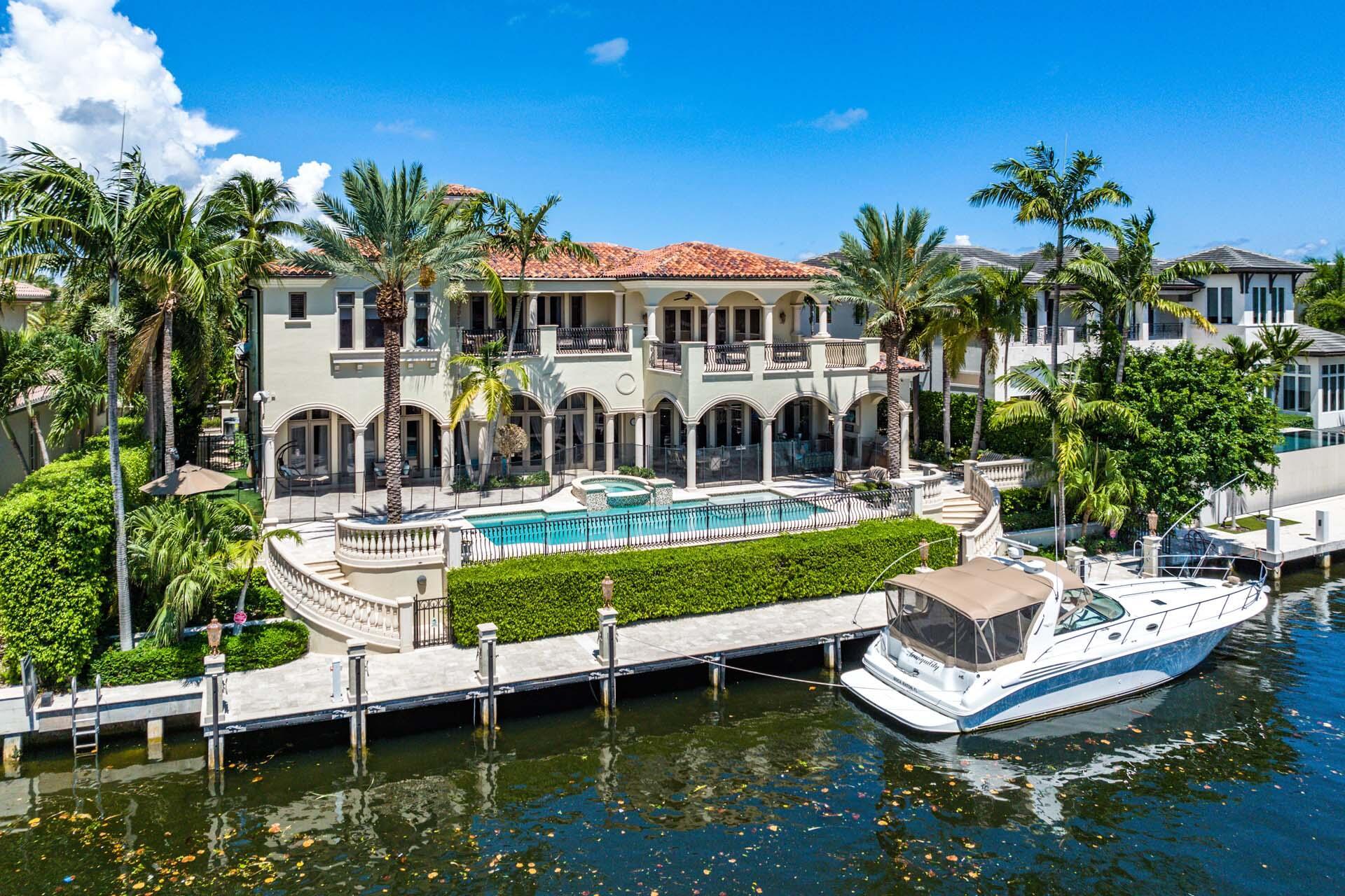 Casa Rosa is a grand waterfront estate located on 112' of the most expansive waterway in Royal Palm Yacht & Country Club. Set behind a gated motor court with pristine tropical grounds, this remarkable 7,900+ sf estate was imagined by Benedict Architecture and garnished with designer finishes by Marc Michaels Interiors. From the imported Portuguese limestone floor to the generous hand-carved trim, there were no details overlooked. The 5-bedroom, 6.1-bathroom home offers an oversized chef's kitchen, home theater, handsome clubroom, private study, 3 fireplaces, elevator, and spacious second-floor lounge. The main suite enjoys waterway views from the covered balcony, a massive suite with sitting areas, and beyond the foyer reception are His & Her spa-like bathrooms with boutique closets. The