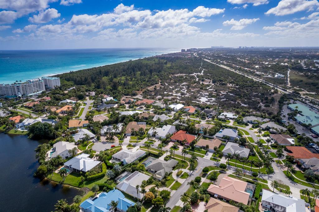 Steps to Jupiter's sun-soaked sand & turquoise waters, this 4117 SF architectural masterpiece opens to a dramatic foyer overlooking pool & spa! Spiral staircase, soaring ceilings, Euro kitchen, formal dining, billiards/exercise room, and 5 bedrooms w/ primary on the 1st floor. Every detail of this home was decided with painstaking precision, including the orientation, walls of windows, & skylights to allow for the perfect balance of natural light & conscious conservation. Special features include a 4-car garage, bountiful storage, whole house water system, and gardens. Olympus is a upscale, unique, and small seaside community of custom single-family homes built on oversized lots. Located between US 1 & beach, enjoy tennis, quiet cul-de-sacs, a large lake, lighted sidewalk, & ocean breezes.