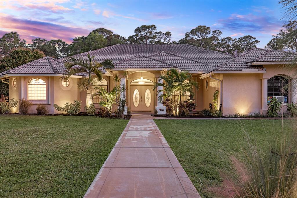 Looking for a spacious ranch-style home with LAND? Look no further than this stunning, custom-built 4 bedroom (plus an office/den), 3 bath home in Loxahatchee!Nestled on a sprawling 1.8-acre lot landscaped with coconut, banana, orange and mango trees, this home offers plenty of room to stretch out and enjoy the Florida sunshine. With its charming ranch-style design, this home boasts a warm and inviting atmosphere that is perfect for both relaxing and entertaining. Smart home and efficiency features include brand new solar panels, touch-entry locks, 15,000 KW Generator, osmosis water system in the kitchen, newer water softener, new irrigation, improved exterior drainage and electric vehicle charger. Full hurricane protection with accordian and panel shutters. Detached shed with electric Step inside to discover a spacious triple-split floor plan that flows seamlessly from room to room. The living room features plenty of space and great natural light, while the adjacent dining area is perfect for hosting dinner parties or family gatherings.

The gourmet kitchen is a chef's dream, with sleek stainless steel appliances, granite countertops, and ample storage space for all of your cooking essentials. And when it's time to retire for the night, the master suite offers a peaceful retreat with a spa-like ensuite bath and plenty of closet space.

But perhaps the best feature of this home is the incredible outdoor space. With over 1.8 acres of lush greenery and mature trees, there's plenty of room for kids and pets to run and play. And with a large patio area, you'll love entertaining guests or simply relaxing and soaking up the Florida sunshine.

Easy access to top-rated schools, shopping, dining, and entertainment. So why wait? Schedule your showing today and start living the Florida dream!