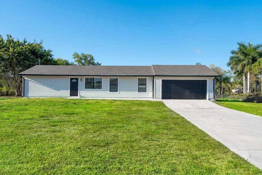 ***Paved Road, City water, New Roof***3 bedroom 2 bath  2 car  garage on a 1.23 acre lot. Located on the most desirable Road in Loxahatchee (Hamlin Blvd).  Home has New AC (2023), New Roof (2023), New Kitchen (2023), New Floors (2023) and updated bathrooms.  Come see why million dollar homes are popping up along this road.  An absolute great investment for the price.  The lot gives you space for all your toys.  Don't delay book your showing today!!