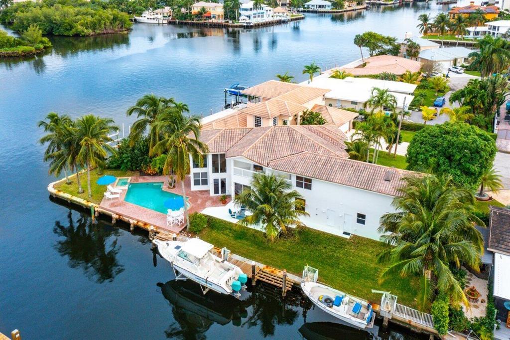 Incredible intracoastal point lot minutes from the Boynton Beach inlet is a rare gem. Located in the exclusive waterfront community of Boynton Isles at 955 Isles Road, this 4 bedroom, 4 bathroom two story home was custom designed by Randall Stofft Architects and offers everything needed to lead the ideal Florida lifestyle. With over 150 feet of water frontage, this home offers direct intracoastal access and comes equipped with a 12,000 lb. boat lift. The front exposure of the home is shrouded by mature landscaping, most notably a large, bountiful mango tree, providing shade over the driveway and the home's oversized western facing front windows. Entering through the double front doors, the first thing you'll notice is just how much natural light radiates through the giant floor to ceiling windows that frame the open living area, inviting expansive water views into each room.

The custom designed kitchen features wood cabinets and granite countertops, with stainless steel appliances, wine cooler, and an eat-in bar area. From the kitchen and living room, you can access the stunning pool and patio area that overlooks the intracoastal.

There are two bedrooms on the first floor, one of which has been converted into a Media room with a 10-foot screen and has access to the outdoor patio. The second bedroom is tucked away on the other side of the home. Each bedroom has its own private ensuite bathroom.

Upstairs, the master suite offers luxury and views. Beautifully renovated recently, the suite features built-in bookshelves, a private terrace that overlooks the intracoastal, and a spa inspired master bath that includes a soaking tub, his and hers vanities, a two-person shower, and walk-in closets. Just off the master is an office with access to the upper terrace with views of the water. An additional bedroom with ensuite bathroom rounds out the second floor.

This home features a custom designed, intracoastal facing office and built out two car garage with full width cabinets and countertops. Boynton Isles is a very walkable neighborhood, close to all the amenities of suburbia but just minutes away from the night life of Downtown Delray Beach.