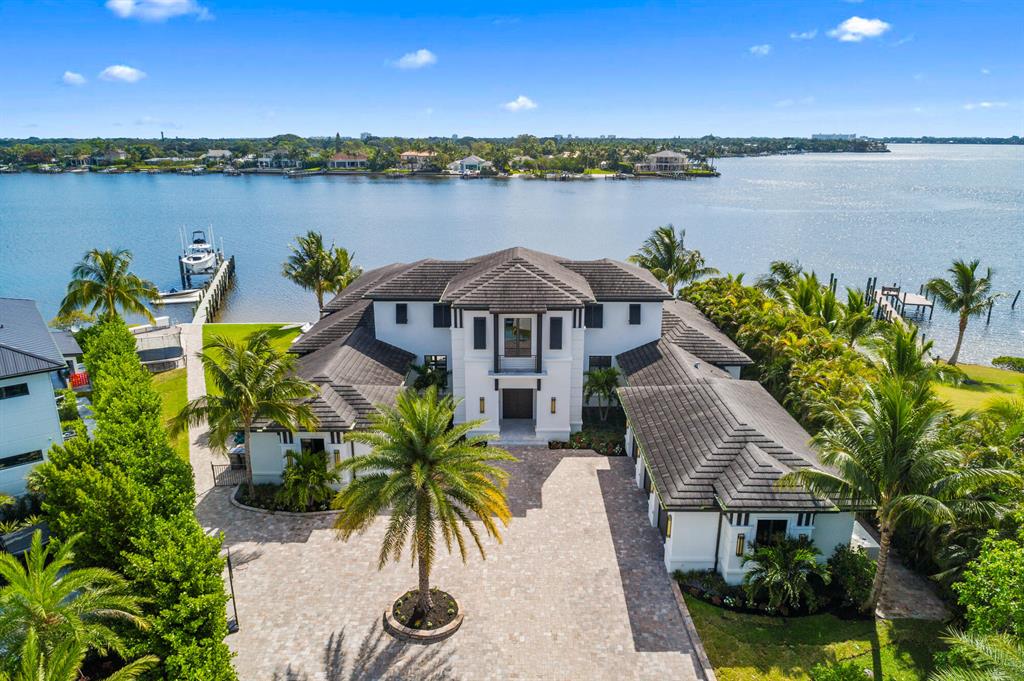 Contemporary British West Indies home built in 2016, with 200' of riverfront, on the widest part of the Loxahatchee River, is filled with modern flair and luxury finishes throughout.  This 4 BR/4.5Bth/4-car garage residence, with study/office and exercise rooms, is located on a quiet street and offers wide/panoramic water views from every room. Enter through a dramatic foyer and behold the stunning water views surrounding the formal living room with custom ceiling and linear gas fireplace. A luxury chandelier hangs from a custom ceiling and dazzles your guests in the waterfront formal dining room. The chef's kitchen is a stunning place to gather and comes equipped with a large prep island, custom cabinetry, quartz countertops, walk in pantry and top of the line stainless steel appliances, including Thermador six-burner gas cooktop, dual ovens, microwave, and Sub-Zero refrigerator. The spacious family room comes equipped with two sets of pocket sliding doors that open up to the patio/pool area. The first-floor master suite offers a dramatic master bathroom and enormous walk-in closet. A beautiful staircase leads to a second-floor family room with wet-bar, balcony and two large en-suite bedrooms. Additional interior features include marble and hardwood floors, designer fixtures, elevator, state of the art security system and hurricane windows and doors throughout. The exterior features of the home include a gated entrance, decorative paver driveway, lush tropical landscaping, large, covered patio with summer kitchen, vanishing edge heated pool, seawall, dock and approximately 200' of river frontage.
Location, location, location, Jupiter is known to be the best town. The area offers exceptional A-rated schools, great restaurants that you can access via boat, car or walking &amp; proximity to world-class shopping.  The world's best beaches; Jupiter Island, Jupiter Inlet Colony, Jupiter and Juno Beaches.  Some of the best snorkeling &amp; fishing in Florida is right off the dock in the turquoise blue water behind the house. 
