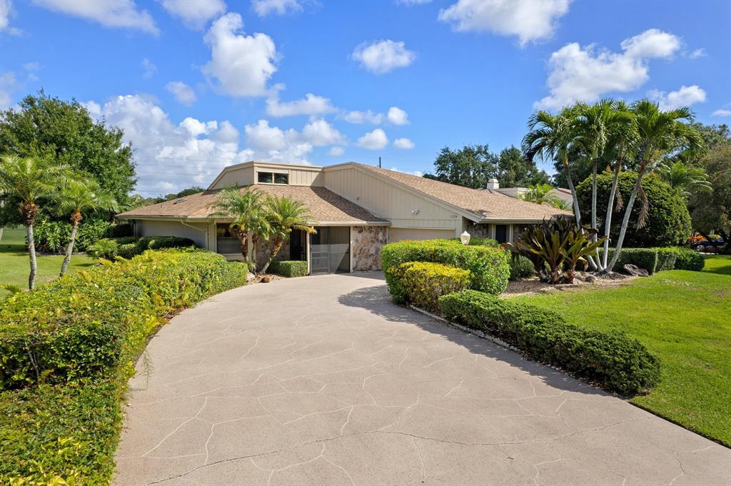 Almost 3,000 total square feet all on one floor, with wide golf course views, on over 1/4-acre lot.  Open and bright living area with dramatic 18-feet tall cathedral ceilings, loaded with natural light.  Newer central air.  Clean white ceramic tile floors throughout.  Updated both bathrooms with ''Granite'' and solid ''Maple'' cabinets, and modern showers.  Huge laundry room, plus bonus storage room.  Extra long driveway for lots of parking.  50-feet wide screened patio.  3 walk-in closets.  24-hour manned gated community, with wonderful clubhouse, golf course, putting green, driving range, swimming pools, tennis, pickleball, fitness center, restaurant.