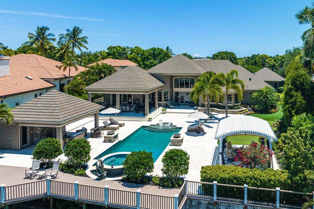 Indulge in waterfront luxury at this French-inspired masterpiece in Admirals Cove. Seamlessly blending traditional elegance with modern sophistication, this single-story haven exceeds expectations. With cutting-edge technology, including a Vantage lighting system and integrated sound, every detail enhances the ambiance. The dream kitchen boasts top-of-the-line appliances, while the backyard oasis offers a pool, spa, and captivating flame burning urns. Additional features include an office, guest house, and media room. Meticulous attention to detail and exquisite craftsmanship are evident throughout. Experience the opulence of this home in person and embrace refined luxury. Welcome home.