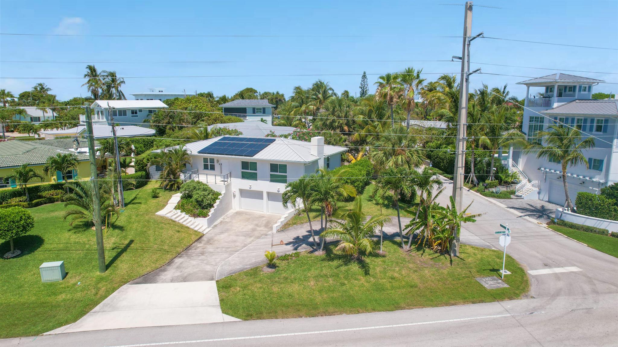 Be ready to fall in love with your beach area retreat in Juno Beach. This lot has the opportunity for ocean views if you build up. It sits high above Ocean Drive with beautiful views of Pelican Lake. The home was renovated with all of the attention to detail.  There are 3 bedrooms, 2 bathrooms, and a bonus separate office space. It features 120 feet of Ocean Drive frontage with easy beach access only a block away. There's a garage with electric car (NEMA 14-50) outlet, solar panels powering the house, and hurricane impact windows and doors. The backyard is full fenced and is lushly  landscaped with tropical fruit trees and vines. This is an ideal property to enjoy part of the year and have rental income too. It is approved and ready to rent out as an Airbnb. There are no HOA restrictions.