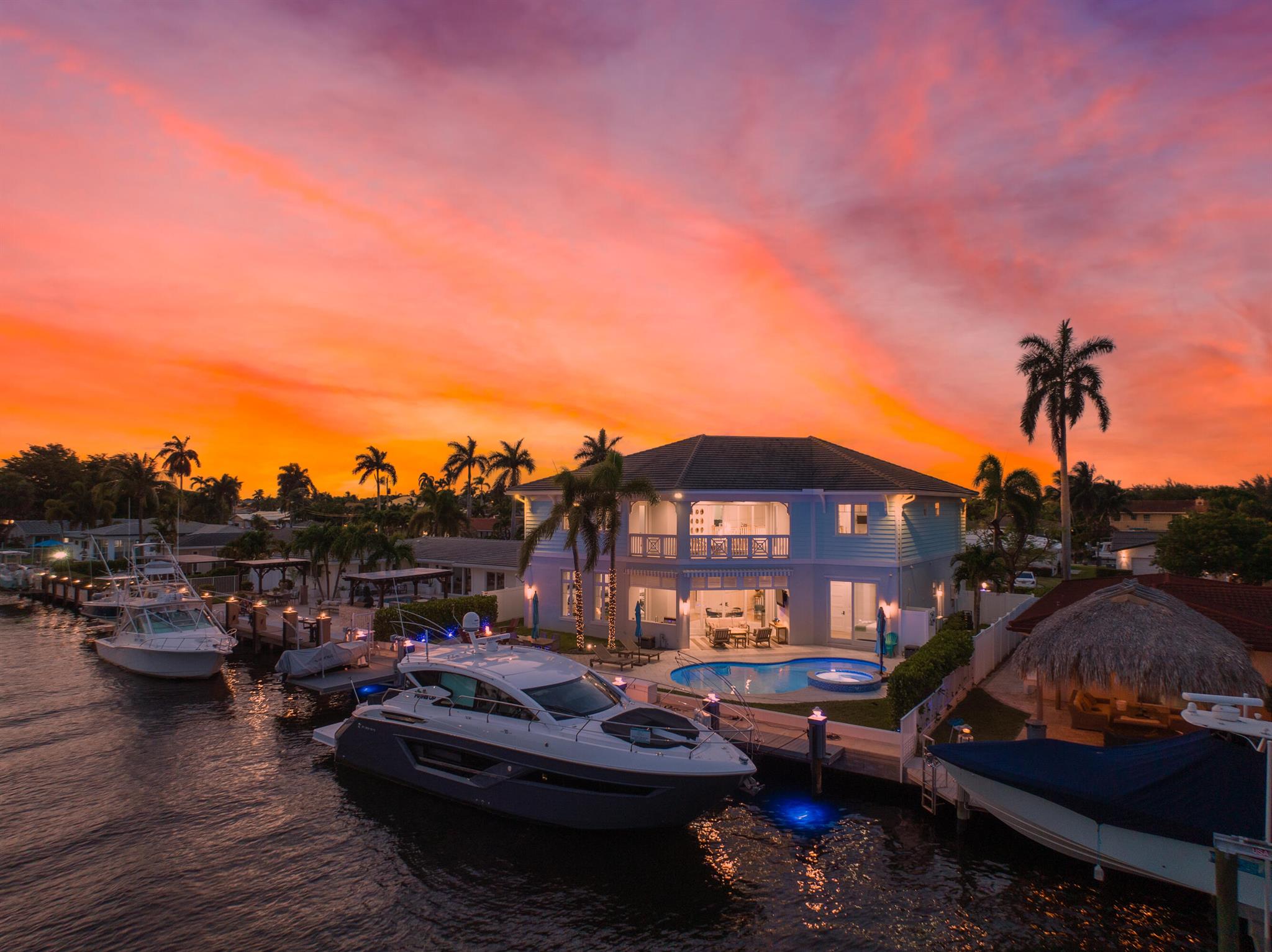Stunning British West Indies-inspired deepwater estate in the exclusive enclave of Pompano Beach, Florida. Overlooking the Capri Canal, this estate features more than 80 feet of water frontage, offering direct Intracoastal and ocean access, and is only minutes from the Hillsboro Inlet. This home is an epitome of luxury living, encased in luminous glass rooms with breathtaking views of the waterway and a resort-style pool. Engineered with smart home automation, this estate extends its intelligent features to all corners, including the garages. The Chef's Kitchen is a classic blend of chic design and modern amenities, boasting Sub-Zero and Wolf appliances, a gas range with natural gas hookup, and an island breakfast bar. The quartz countertops, full tile backsplash, and ambient LED lighting add a touch of elegance, while the under-mount kitchen sink and modern wall-mount pot filler ensure practicality. The primary suite is a haven of luxury, featuring spa-like baths, his and hers wardrobes and water closets, a makeup vanity, and a private waterfront balcony. The estate also includes a first-floor in-law suite overlooking the pool and waterways. The outdoor space is a true resort-style retreat, complete with a covered lanai, an outdoor summer kitchen, fire pit, and a cabana bath with an outdoor shower. The 70' composite yacht dock is fully equipped with bumpers, cleats, and a 60 Amp pedestal. The property is built with maintenance-free PVC and concrete block construction, ensuring durability and low upkeep. Notable exterior features include 10ft high PGT impact sliding glass doors, a concrete gas fire bowl, and a concrete balcony with smart home automation. The interior design is an aesthetic delight, boasting a great room design with water views from almost every room. The estate features high ceilings, a clubroom/billiard room, and a formal living room with a natural gas fireplace. The flooring combines European oak engineered hardwood with modern porcelain tile, creating a blend of classic and contemporary. Additional features include a custom-designed double entry door, glass-enclosed refrigerated wine cellars, and custom wallpaper throughout. The property is also designed with energy-saving features such as Low E glass for all windows and doors, 2 tankless natural gas water heaters, open-cell R-20 foam insulation, and high-efficiency air conditioning and heating systems. The state-of-the-art electrical system includes a Lutron lighting control system, an audio distributed music system, and a 600 AMP underground service to the house and 60 AMP service to the dock. The estate is also pre-wired for a Generac 200 Amp Smart transfer Switchgear with 100amp panel with natural gas. This deepwater estate is a perfect blend of classic design and modern technology, offering luxury living with a touch of nature's bliss. Whether it's the luxurious interiors, the smart home features, or the resort-style outdoor amenities, this property is truly a testament to refined living.