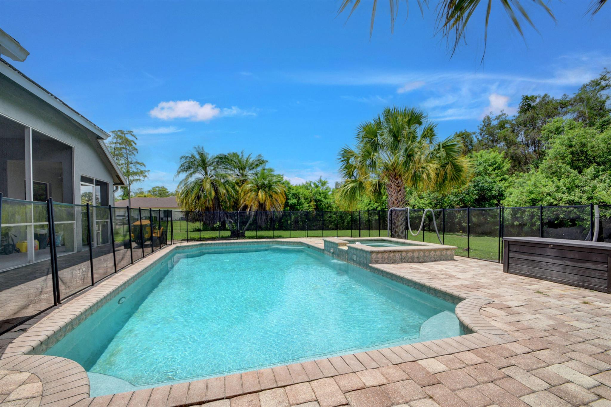 Come enjoy the privacy and seclusion of Loxahatchee Living in this 3 Bed 2 Bath 2 Car POOL home on a 1.14 acre spread. Built in 2004 with CBS Construction the home has a spacious open floor plan with vaulted ceilings, a Formal Living Room, Formal Dining Room with a Great Room Concept of Kitchen, Breakfast Area and Living Room. You'll enjoy the split floor plan and the sliders offering great views of the Pool/Spa with Child Protection Fence and fully-fenced backyard. An extra-long driveway allows you to bring Boat, Truck, RV or all 3. More than $10,000 in recent upgrades including new dishwasher in 2023, new washer & dryer in 2022 and a new water softening system in 2020-2021.