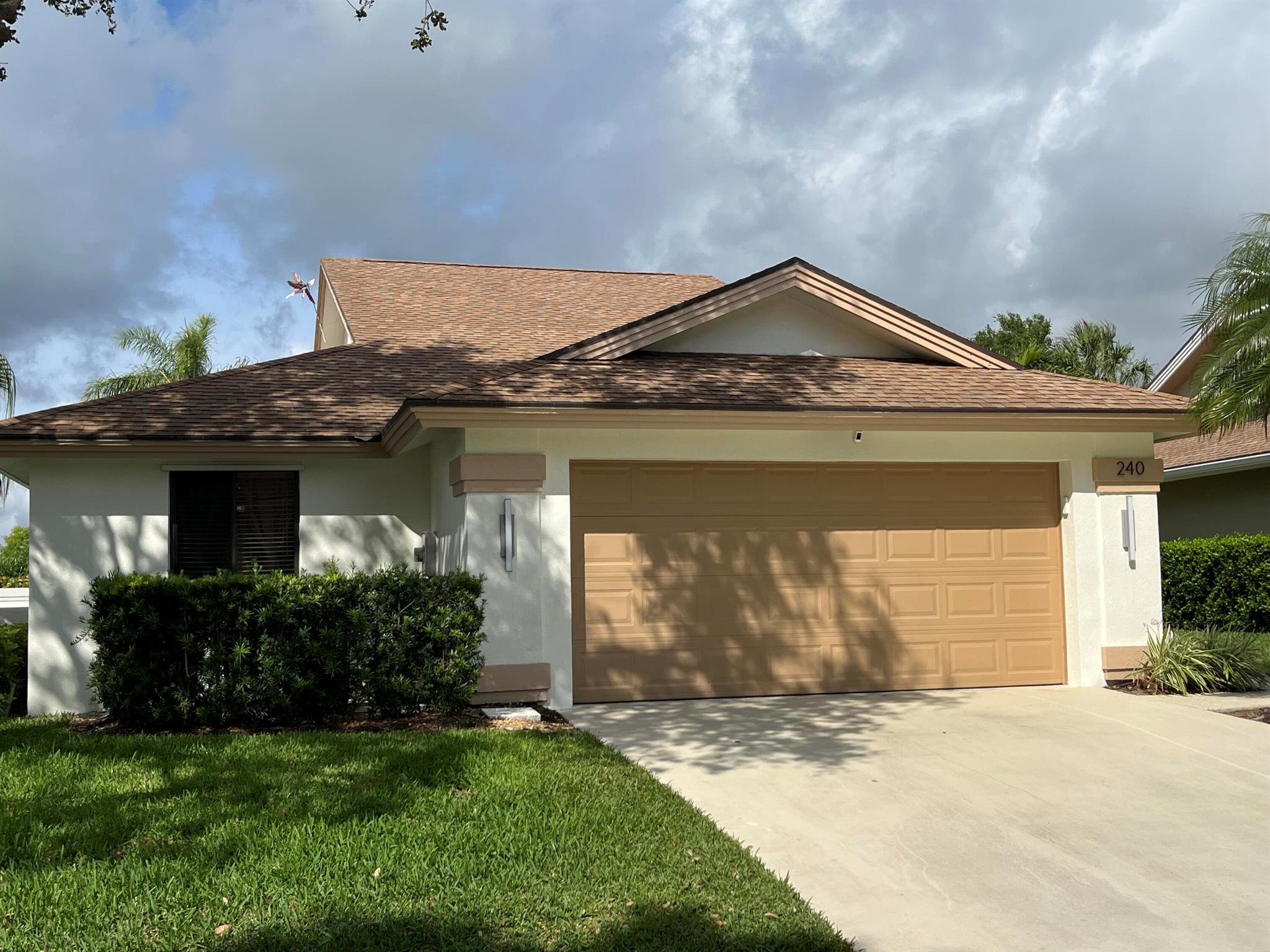 Ridge Road, the street most desired. This is your opportunity to move in a Bluffs single family home and live SO close to beautiful Jupiter Beach. This 3 bedroom, 2 bath, 2 car attached garage home features vaulted ceilings, walk in master closet, renovated master bathroom, numerous glass sliding doors that open up to a nicely landscaped topical backyard. Enjoy grilling that steak on the built in grill, take an outdoor shower after coming home from the beach or community pool and relax after using the electric awnings for perfect shade while watching beautiful sunsets in the evenings. The community recreational facility offers a large pool, tennis, pickleball, basketball plus more. A resort lifestyle for sure.