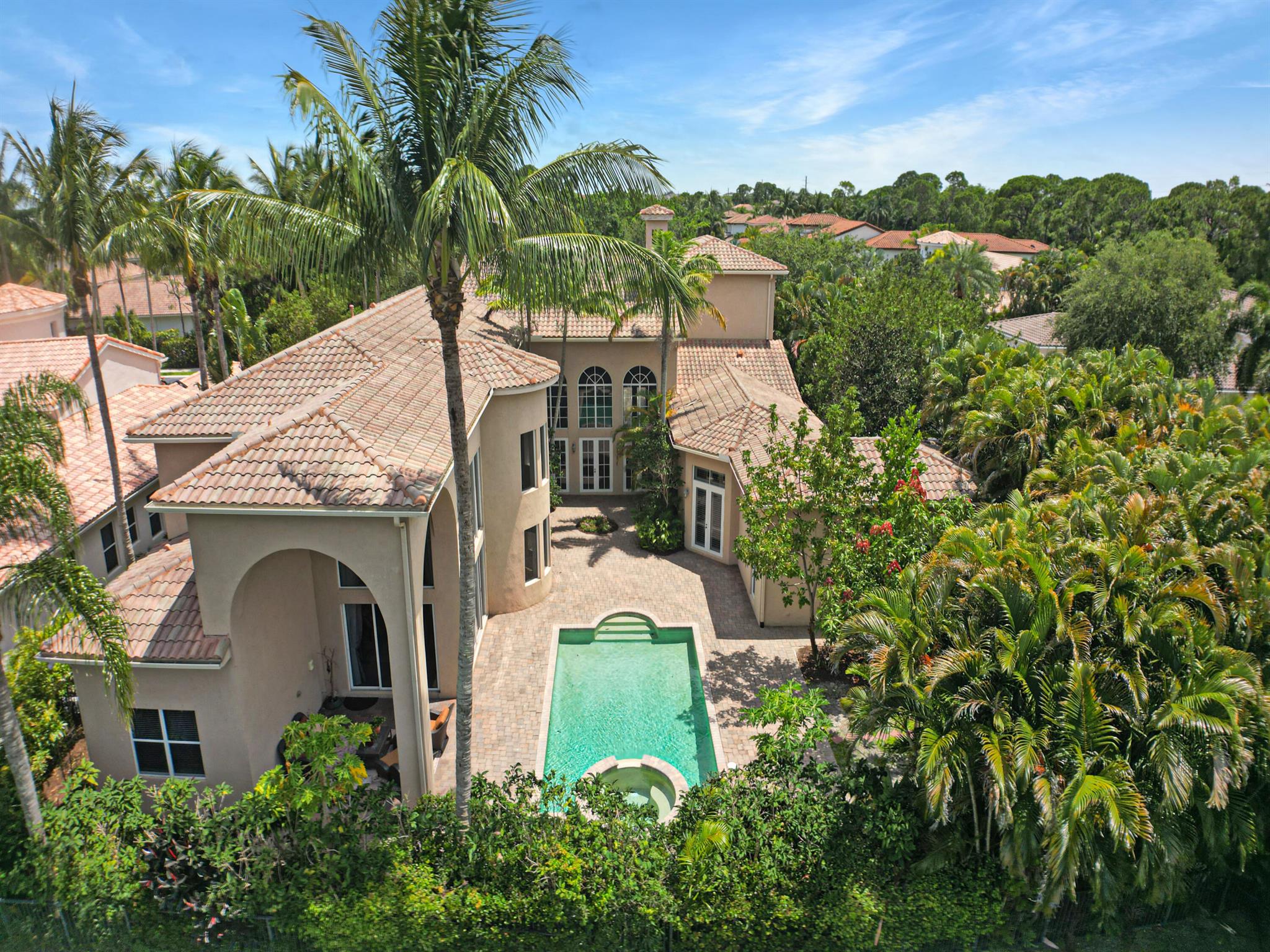 This stunning luxury lakefront pool home, located in the heart of Palm Beach Gardens, is a shining example of San Michele's finest properties. Nestled on a quiet street, the Valdarna model boasts 6,346 square feet of air-conditioned space, featuring 6 spacious bedrooms and 7.5 bathrooms. The floor plan also includes an office, media/playroom, a custom-added nursery room behind the prime suite, a loft, and a wet bar. The spa and pool in the courtyard overlook a serene lake, creating a peaceful oasis for residents.  The gourmet kitchen is a chef's dream, with a 8 burner range, granite countertops, a chef's island, a butler's prep area with a warmer, and a solid wood walk-in pantry. The prime suite is its own oasis.  Walking into the French doors, there is a mini bar with a refrigerator  , his-and-her walk-in closets. Built by Gordon Builders in 2006, this home exudes elegance and functionality with a fireplace, travertine floors, a black wrought-iron spiral staircase that showcases the magnificent 21.5-foot high cathedral ceiling, triple French doors, arched windows brightening up the living room, plantation shutters, custom draperies, and an ample yard with lush landscaping filled with avocado, mango, and papaya trees in the garden, and a four-car garage with an electric charger is located on a governor's drive.  San Michele is a private  24/7 manned gated community that boasts 90 large estate homes, known for its beauty and quality construction, and this is the largest model available. The community offers low HOA dues with the benefits of amenities for an active lifestyle, including Har-Tru clay tennis courts, a community swimming pool, a fitness center, and a well-appointed clubhouse. Conveniently located near shopping, dining, schools, the beach, and the airport, this home's location is ideal. With top-rated schools and just over 2 miles from the beach, this is the perfect place to call home. Book a private viewing today and experience luxury living at its finest. You will not find this large size estate in most ideal location with NO equity membership!  THIS HOME IS PRICED TO SELL!