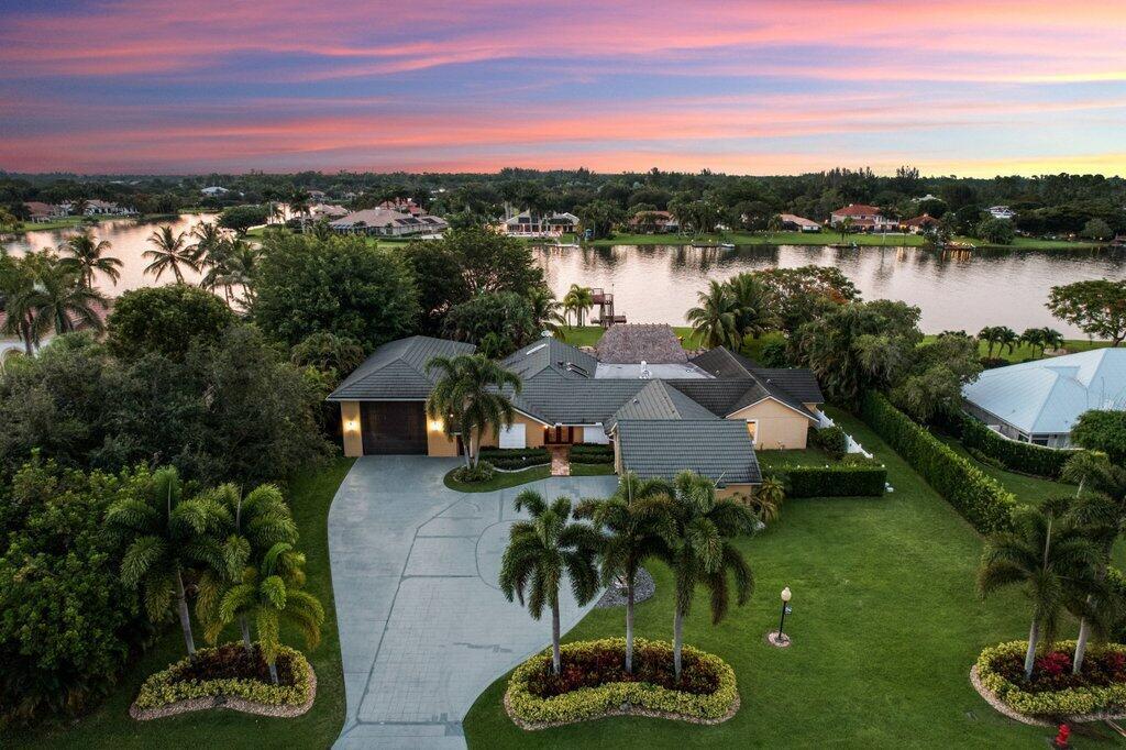 Welcome to Banyan Lakes, a prestigious gated community that offers an active waterski and boating lifestyle. This stunning 5-bedroom, 4-bath home is situated on a spacious 1-acre tropical oasis, providing the perfect retreat for relaxation and entertainment.As you enter the community, you'll notice a $500,000 community enhancement project, including newly paved roads and an impressive, gated newly reconstructed entrance way at the Western entrance off of Lyons Rd.Upon arrival to your new home, you will admire the oversized driveway with separate entrance for the detached garage. Enter through the double doors and prepare to be swept away. With exotic bamboo flooring extending throughout the home, you will notice an open, split floor plan overlooking your own tropical oasis.