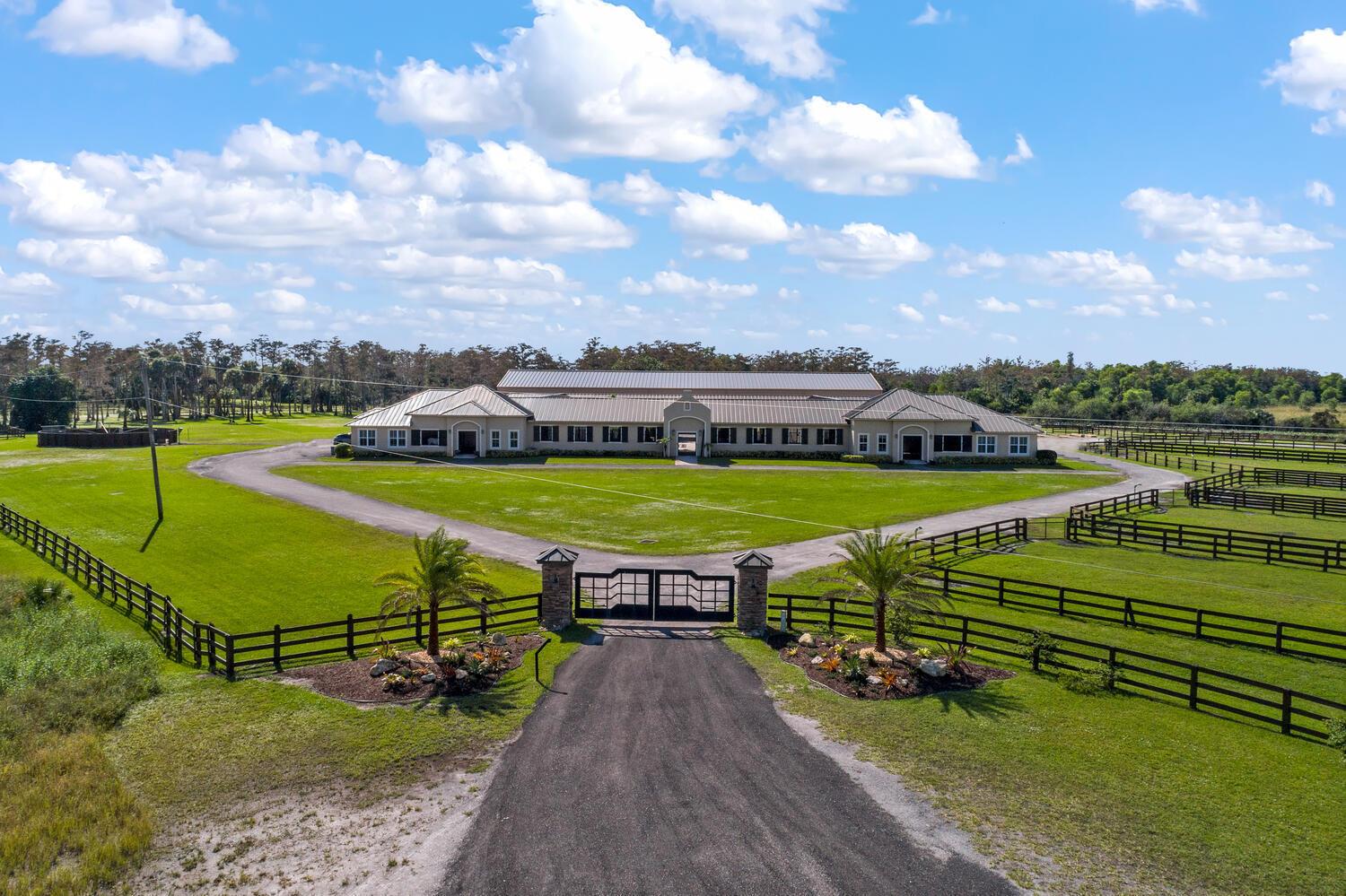 This 24-stall courtyard-style stable & training facility offers total flexibility of use. Situated on 14 acres, the stable's mirror image layout allows perfect privacy for your horses, separate from boarders.  There are 2 tack & 2 feed rooms, 2 wash-rack areas, and 2 apartments, totaling 6Br.  Horses relax in this Florida open-air design with tranquil views to the inner-patio sanctuary.  There is a 4Br/2Bth apt.  on the East end of the stable and a 2Br/2Bth apt. on the West end.  Both have a primary bedroom w/ in suite bathrooms. Adjacent to the stable is the covered arena (199' x 67') with GGT footing & attached storage garage (61' x 31' totaling 1,891 sq. ft.), a 4-horse exercise walker & 12 grass paddocks. There is plenty of room for an outdoor arena & to build your custom estate home!