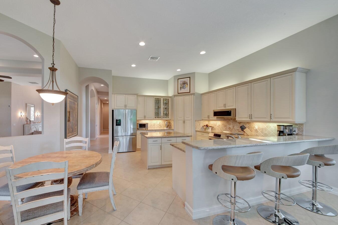 Welcome to this exquisite residence that seamlessly blends elegance with practicality. As you approach the home, you'll be greeted by the grandeur of the largest front yard in the neighborhood. Passing through the inviting glass front door, you'll step into a haven of comfort and sophistication. The neutral flooring, a canvas of refined tones, stretches throughout the open-concept living spaces, creating a serene and cohesive ambiance that allows your personal style to shine. Sunlight dances through the expansive windows, casting a warm glow that illuminates the living area, adorned with a seamless combination of classic and contemporary design elements. The living room effortlessly transitions into the dining area, ideal for hosting intimate gatherings or lavish dinner parties. The heart of the home is the kitchen, a culinary enthusiast's dream. Custom cabinets with pull-outs not only provide ample storage but also offer a glimpse into the seamless blend of form and function. The granite countertops, tiled backsplash and stainless steel appliances set the stage for culinary creativity, while the spacious layout ensures that meal preparation is both a joy and a breeze. An essential feature of this home is the accordion shutters, a testament to both style and safety. These shutters add an extra layer of protection. The primary suite is a sanctuary of tranquility, with its generous proportions, plush carpeting, and en-suite bathroom that rivals a spa retreat. The primary bathroom boasts luxurious finishes, including dual sinks, a soaking tub and a walk-in shower, creating an oasis of relaxation.
Step outside to the backyard, a private escape designed for outdoor living. The screen-enclosed patio, seamlessly integrating indoor and outdoor spaces. Whether you're lounging under the sun or entertaining under the stars, this space offers endless possibilities for relaxation and recreation.
In every corner of this home, attention to detail and thoughtful design converge, offering a harmonious blend of elegance and practicality. With its neutral flooring, coffered ceilings and high hat lighting this residence is more than a house - it's a canvas for your ideal lifestyle.