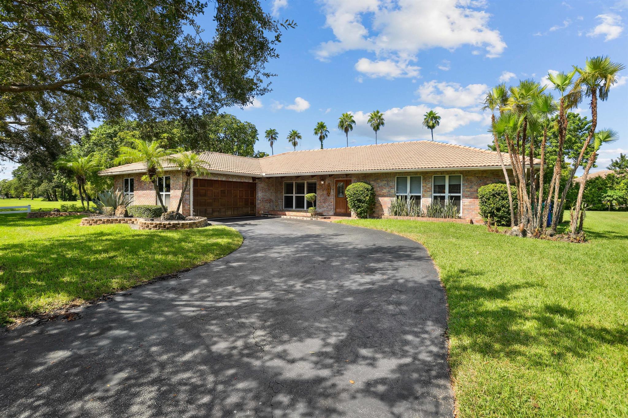 Welcome to this stunning home located in the desirable Oak Wood of Coral Springs. Boasting 4 oversized bedrooms, 2 renovated full baths, and 1 half bath, this 2,764 sq. ft. residence offers plenty of space for comfortable living. Step inside and be greeted by the inviting vaulted exposed beam ceilings, new wood floors and freshly painted walls that all add a touch of character and charm to the home. The dining room and living room with bay window provide the perfect spaces for entertaining guests or enjoying a quiet evening in. The family room is adorned with three sets of French doors, allowing natural light to flood the space. Prepare culinary delights in the oversized kitchen, complete with granite countertops, double ovens, two islands, stainless steel appliances, and a wine cooler. The renovated cabana bathrooms feature LED dimmable mirrors, modern vanities, beautifully tiled showers while the dual primary en suite bath offers a luxurious retreat with a freestanding tub and a spa-like shower. The primary suite offers a seating area, 2 walk-in closets and beautiful french doors leading to the outside. Outside, the home is situated on a generous 1/3-acre lot, providing ample space for outdoor activities. Take a refreshing dip in the pool or unwind in the spa, creating your own private oasis under the lanai. Enjoy entertaining or relaxing under the covered patio with amble seating space and BBQ area. The screened-in porch on the side of the home can be converted into an office or an additional bedroom or kept as is for the perfect workout space with ceiling fan. The newly fenced-in oversized yard offers privacy and security for you and your loved ones. With a 2-car garage that has been newly epoxied and painted, there is plenty of room for parking and storage. Located on a corner lot with no neighbors on one side, this home offers a sense of tranquility and seclusion. Additionally, the home is conveniently situated next to a 6-acre community park, providing private access and endless opportunities for outdoor recreation. Don't miss the chance to make this exquisite residence your own!