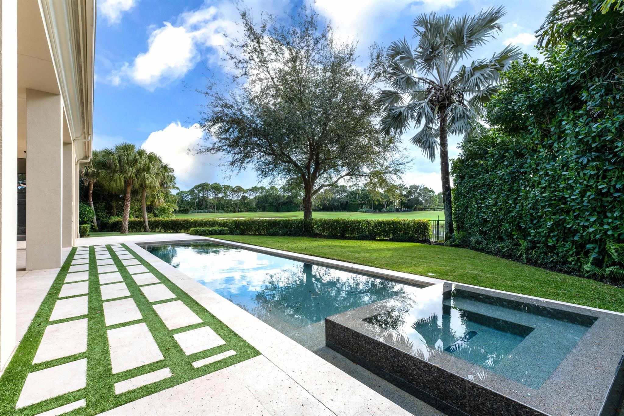 Imagine sitting on a professionally landscaped, travertine deck surrounded by lush plantings, grass, turf, privacy fencing and an unobstructed view of the golf course and lake at the Country Club of Mirasol.  A gracious and grand property created by Courchene Builders, this custom home is situated at the end of a cul de sac on one of the very largest lots in the community! A magnificent flow through a single level floor plan is complemented by soaring coffered ceilings and enormous glass impact windows. This airy, open space is one of this home's most prominent features inviting you to decorate in any interior design you prefer. 5 ensuite bedrooms plus office and an oversized 4 car garage with plenty of storage spaces and a very large, covered screen room for added quiet enjoyment and entertaining.  There are 2 driveways, one a u-shaped driveway, and the other offers ample parking behind the garage. The chef's kitchen includes Sub Zero and Dacor appliances, Calacatta marble countertops, 2 walk-in pantries, microwave, 2 wall ovens, large Dacor cook top, beverage center, and custom cabinetry with pull-outs. From the large kitchen island, enjoy breakfast with unobstructed views of the golf course beyond. Outside the dining room, living room, family room, office, and primary bedroom, the Pool and Spa, designed by Pool Tek of the Palm Beaches, stretches along an architect-designed spacious backyard.  There is a second lanai with turf and travertine lined decking and an open sitting area with travertine deck for lounging and watching the sunsets over the lake and golf course. The family room is open to the kitchen and has a guest/cabana bath access for the outside. There is a guest suite off the living area that has a pocket door to keep that suite private from the living spaces. The new laundry room has quartz countertops, new cabinets with lots of storage and pull-outs, washer, dryer, set tub, and a dog wash, and wet clothes hanging area. There are abundant closet storage areas throughout this home. The primary bedroom is large, open, with several windows and a door that opens to the covered lanai and pool area.  There is new wood look porcelain tile flooring in the primary bedroom as well as 2 other guest suites. The newly renovated primary bathroom has large scale lights, porcelain tile floor and shower, with a sitting bench in the shower. New gold fixtures, a make-up table for her, new lighting, free standing new tub, top of the line Toto toilet, quartzite countertops, and new his and her sinks. The primary bathroom walks out to a beverage area and refrigerator and countertops for snacks. The primary suite has 2 very large closets, (his and hers), and hers even has a cedar closet.  The secondary guest bedrooms are all equipped with walk-in closets and full bathrooms. There is a bar with 2 sides with Calacatta marble tops across from the dining room.  Don't miss this Full Golf Membership, sought after one story private estate home with the most beautiful views in the Country Club of Mirasol! Come escape to your own tropical paradise!