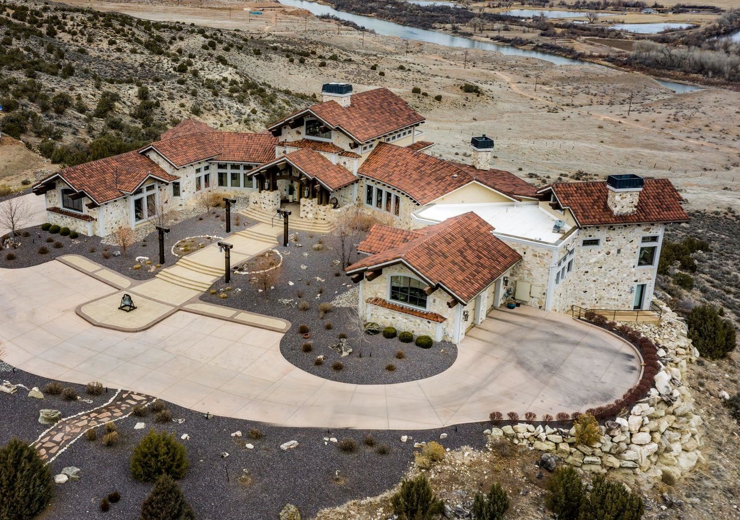 Do not miss your opportunity to own this captivating and timeless Grand Junction Estate. Nestled on 2.35 acres and breathtaking 365 degree views. Inside you will find dramatic 34' tall ceilings, custom travertine floors, an astonishing stone, floor- to- ceiling fireplace, chef's dream kitchen complete with a butler kitchen. The owner's suite has a true retreat feel. The temperature controlled wine room is sure to  satisfy the fussiest wine collector. Every window is a picture perfect view of the cityscape, Colorado River, Colorado National Monument, The Grand Mesa and the Bookcliff's. Downstairs you will find a game room, a custom Home Theatre and a 6 person steam room. The guest wing features a powder room, 2 guest suites (each with en suites) and private entrances. The home has 2 garages on opposite ends of the home. The house was built in 2006 and took over two years to complete. The stone was quarried on site. The home runs on Geothermal for heating and cooling and the exterior walls are 12" thick. Out back you will enjoy those stunning Colorado Sunsets on your ultra private patio. The  suspended patio overlooks the Colorado River and has full city views. This outdoor space is  complete with a fireplace, hot tub and room to entertain all your guests.