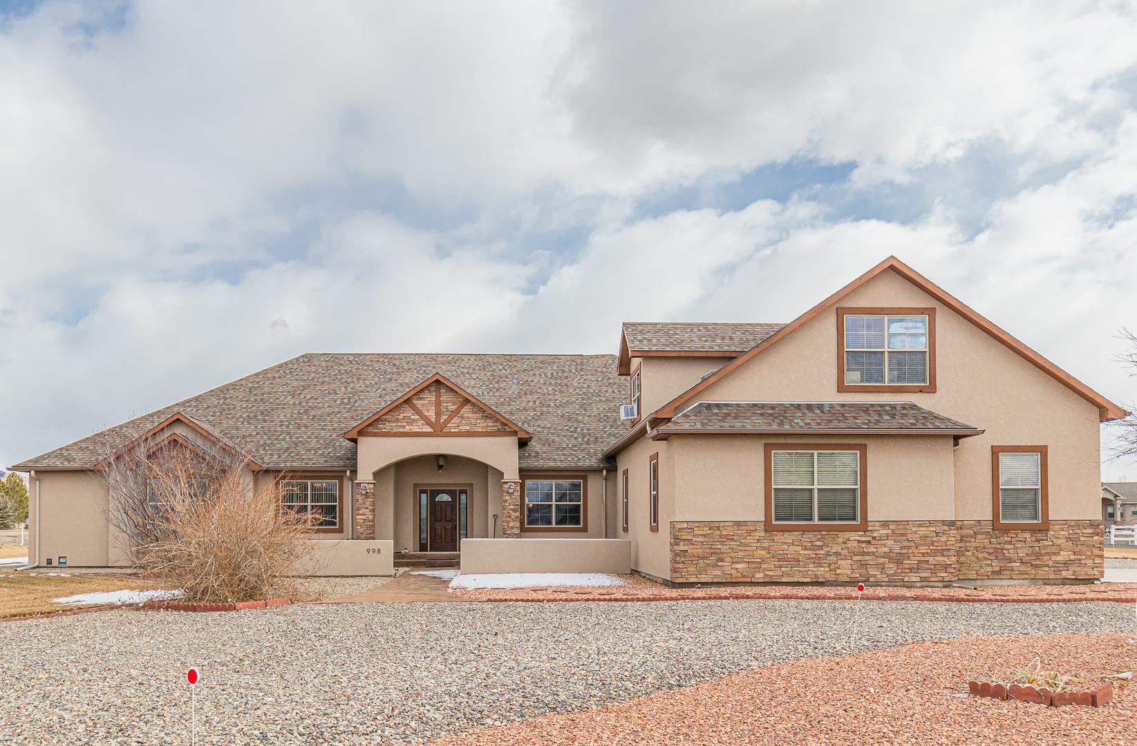 Welcome home! Take a closer look at this custom Colorado-style home! Are you looking for elbow room with room to grow combined with views? This home has it all and more! This 2009 Parade home sits proudly on a 3.02-acre, corner lot located in the Crown Point subdivision in North Grand Junction! You will be greeted with a park-like courtyard, lush lawn and even your own pumpkin patch!   The dramatic archway leads you into the grand foyer where you are invited with warmth and light! The formal dining is sure to impress.  The custom Brazilian walnut with rosewood accent hardwood looks as if it were placed just yesterday!  The gourmet kitchen boasts granite countertops, Custom Knotty Alder Cabinets and Pine Doors complete with roll outs and double ovens and beautiful under cabinet lighting. The generous pantry has a built-in skylight.  Enjoy the sunrise from the eat-in kitchen area! The built in mudroom, utility room adjacent to the master suite also has a built-in skylight. This home was built with entertaining in mind whilst maintaining the split floor plan for privacy.  All of the bedrooms are on the main level each have full walk-in closets. The primary suite offers a complete 5 piece bath, with a custom built in coffee/breakfast bar complete with a refrigerator for beverages or medicines. Say hello to the added 613 sf above- garage bonus room complete with a half bath, could offer movie theater room, flex room, or separate living space. The second primary suite/ mother-in-law suite has a private entrance, with a full bath and walk-in closet. Oil rubbed bronze finishes throughout, picture frame mirrors in bathrooms. Relax in the family/living area and cozy up to the gas fireplace and walk through the double doors out to the 650sf fully enclosed porch, complete with stamped, colored concrete throughout and 2 ceiling fans!   This Energy-Star rated home has updated energy efficiency options. 2 hot water heaters (can switch to single) with instant hot water circulator. out. The 1200SF garage is sure to house your toys, storage and more! The property offers complete RV Parking, with electric hook up, RV Sewer dump. Please refer to the home feature list for full/additional details in listing information or call the listing agent 970-697-4074.  The pride of ownership shines through from every corner, top to bottom! Original owner, no pets have ever lived in or on the property. Please call to schedule your private tour today!