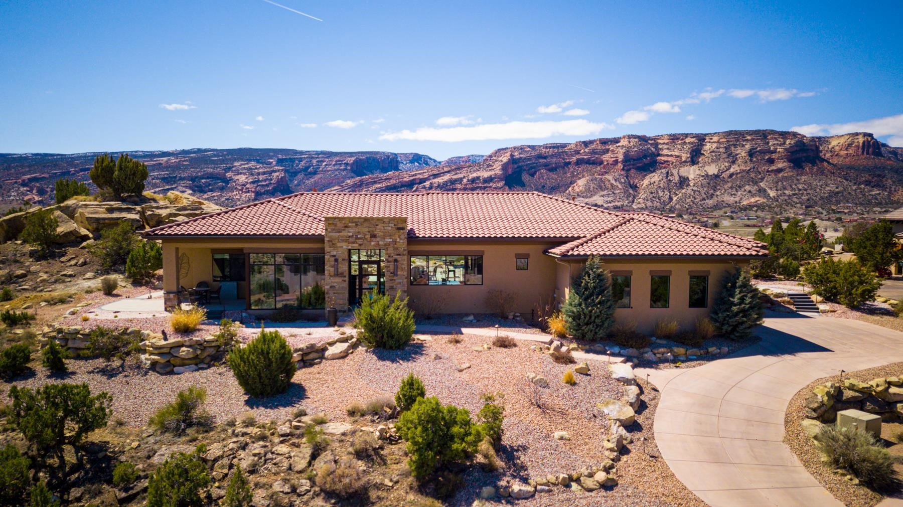Live in one of the premier spectacular settings in all of Grand Junction.  This 3000 sq. ft Conquest built ranch style home is strategically tucked away on the south side of Redlands Mesa.  Located just off the elevated 4th tee box of the highly acclaimed Redlands Mesa Golf Course.  Incredible 360 degree views of the Colorado National Monument, Grand Mesa, Bookcliff Mountains, and the Valley Floor.  Owners own controlling interest in front lot (2327), which guarantees the front corridor views.  Functional open concept floor plan, gourmet kitchen featuring high end appliances and a spacious walk in pantry. Two large entertainment areas with fireplace and formal dining adjoined.  Custom electric auto blinds (no batteries) to easily take in the views.  Hard wood flooring throughout. There are too many custom features to detail. Fabulous professional landscaping with a firepit & covered fireplace area. State of the art custom lighting & cascading waterfall feature. Views, Views, Views!  Must view this spectacular property to appreciate!