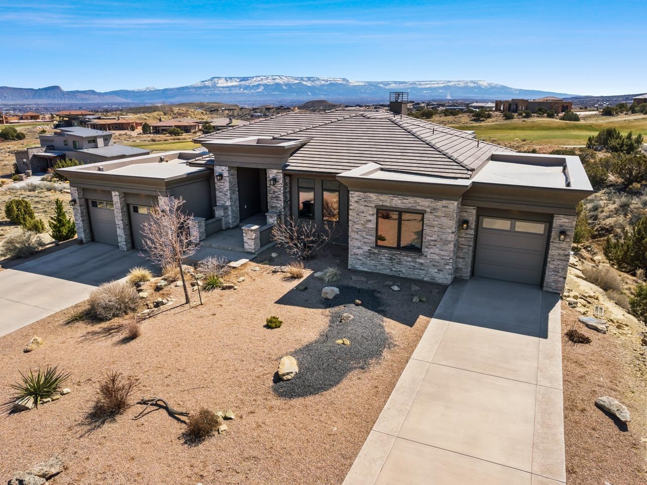 Introducing a luxurious and modern home for sale in the prestigious Redlands Mesa Community. Situated in a prime location overlooking the lushness of the first fairway and surrounded by the natural desert landscape, this stunning property offers unparalleled views and access to the award winning Redlands Mesa Golf Course. Built in 2016, this home boasts a contemporary design that seamlessly blends form and function. The sleek and modern exterior is matched by an equally stunning interior featuring beautiful finishes. Inside, the spacious living areas are flooded with natural light and offer a seamless flow between the indoor and outdoor spaces. Floor-to-ceiling windows provide breathtaking views of the golf course, Grand Mesa, and Bookcliffs, while the open floor plan creates an inviting atmosphere for gatherings and entertaining guests. The gourmet kitchen is a chef's dream, with  ample storage space and a large island with seating, perfect for casual dining, while the adjacent dining area is ideal for more formal occasions. The primary suite is a private oasis, with a spa-like en-suite bathroom and large walk-in closet. Outside, the expansive east-facing deck is the perfect spot to take in the stunning views while enjoying a meal or relaxing with a book, without getting baked by the afternoon sun. Relax in the hot tub instead of mowing grass - as the extra-large lot is low-maintenance and provides protection for your views. The home also comes fully furnished with the perfect decor and accouterments. This home truly has it all - luxury, views, modern design, and access to one of the best golf courses in Western Colorado. Just around the corner from the clubhouse, restaurant and bar! Don't miss your chance to own this exceptional property in the Redlands area of Grand Junction.