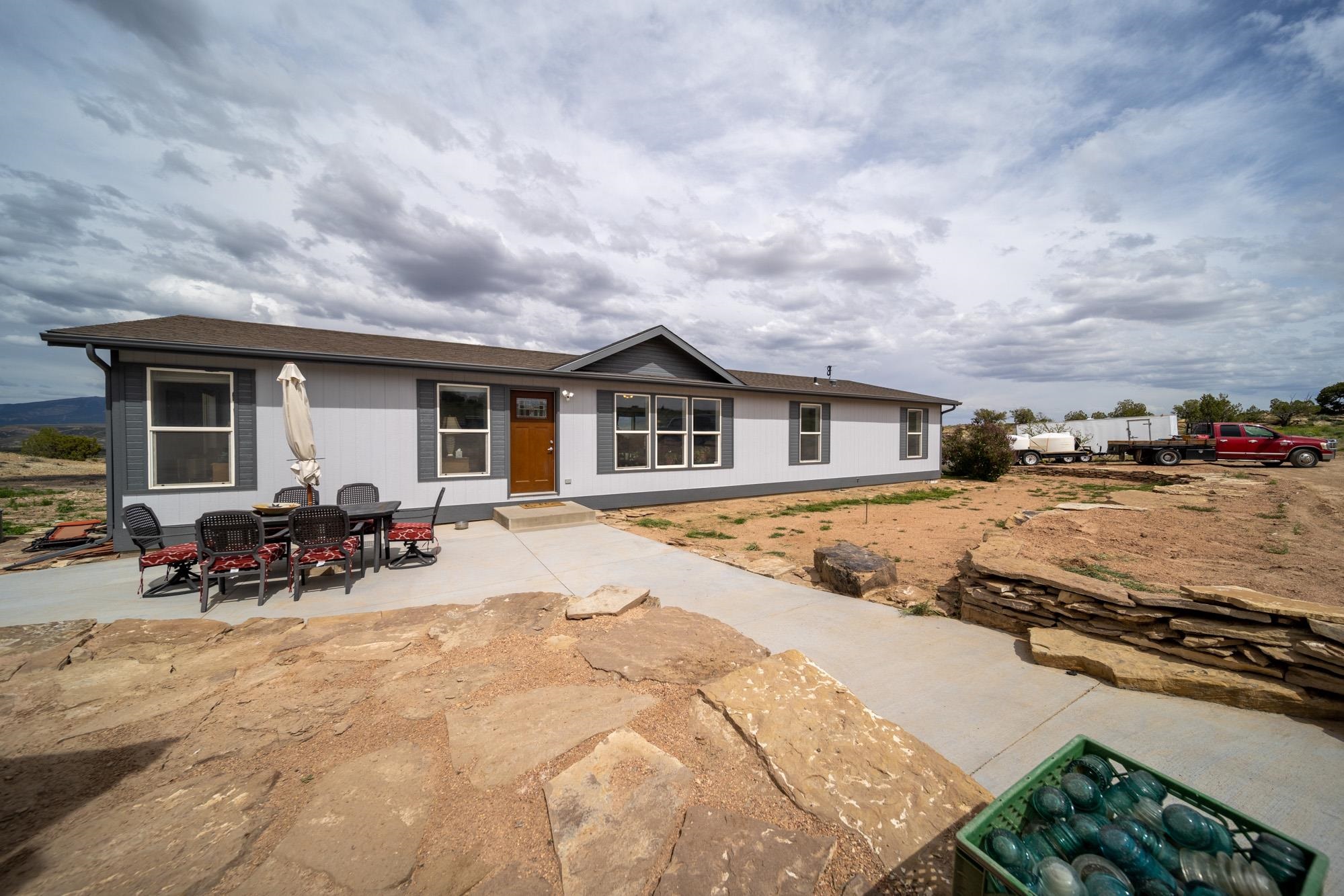 This well maintained, beautiful home sits high on 40 acres with 1782 sq ft, 3 bedroom, 2 bath. You'll find breathtaking unobstructed views of the entire Mesa and surround from the 12'x 26' deck. The property is bordered on 3 sides with the Dominquez-Escalante National Conservation Area; BLM land that allows for easy access for your 4-wheelers, horse back or extensive hiking - plenty of freedom! The detached (shop) garage is 24'x30' with 220 electric in place. The exterior of the home and garage has been freshly painted. Open floor plan with vaulted ceilings giving a spacious feel. Split bedroom design. All upgraded appliances included. Xeriscaped for easy care.