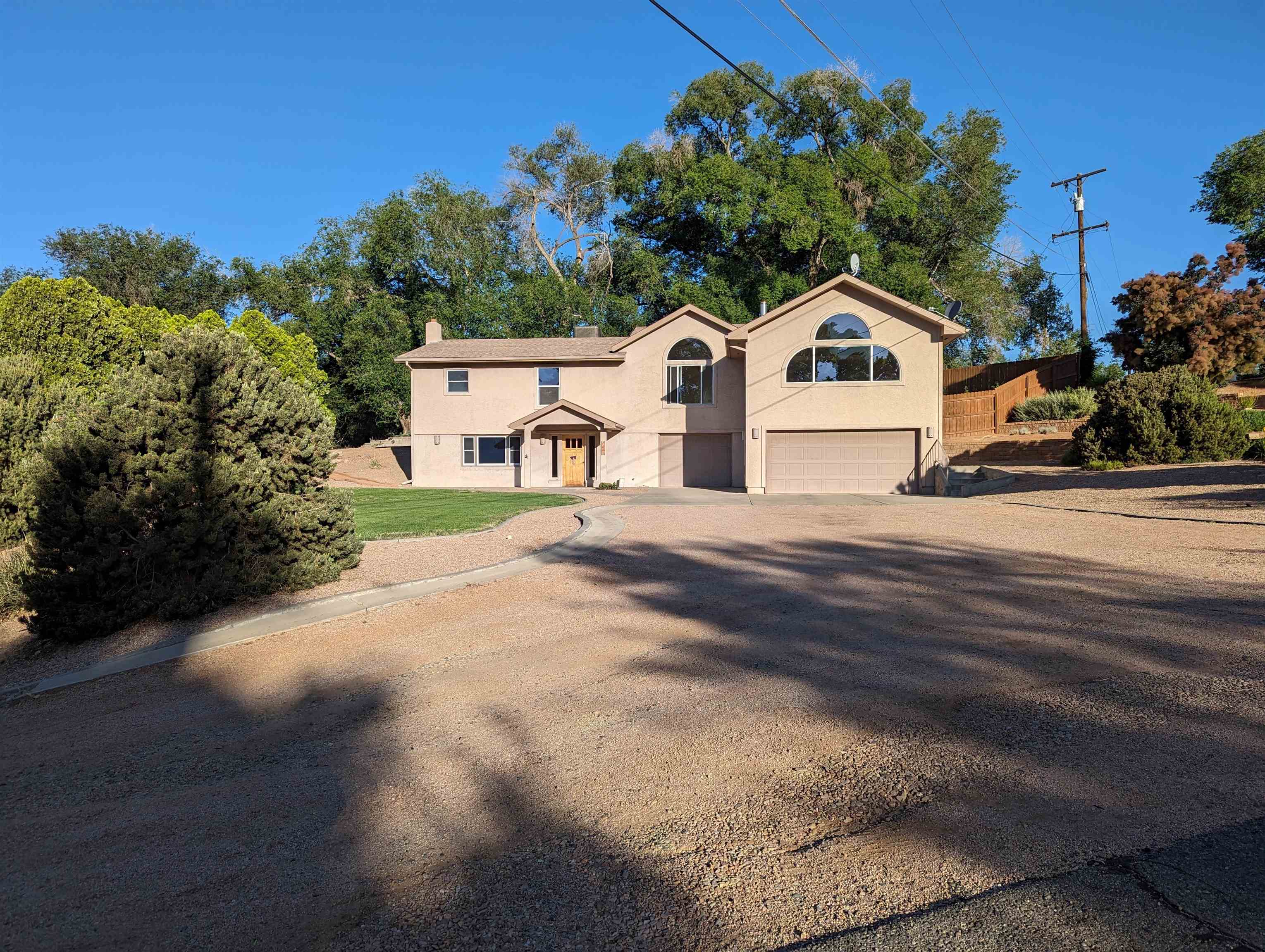 Prime location close to schools, shopping, and medical facilities. Beautiful natural light in upper level with extra large kitchen/dining/living area with gas fireplace. 90% xeriscaped with back entertainment area. This area has a wired hot tub location, extra large parking/driveway area for all your vehicles and toys - plus a 3 car garage! This home also has one share of Grand Valley Irrigation.