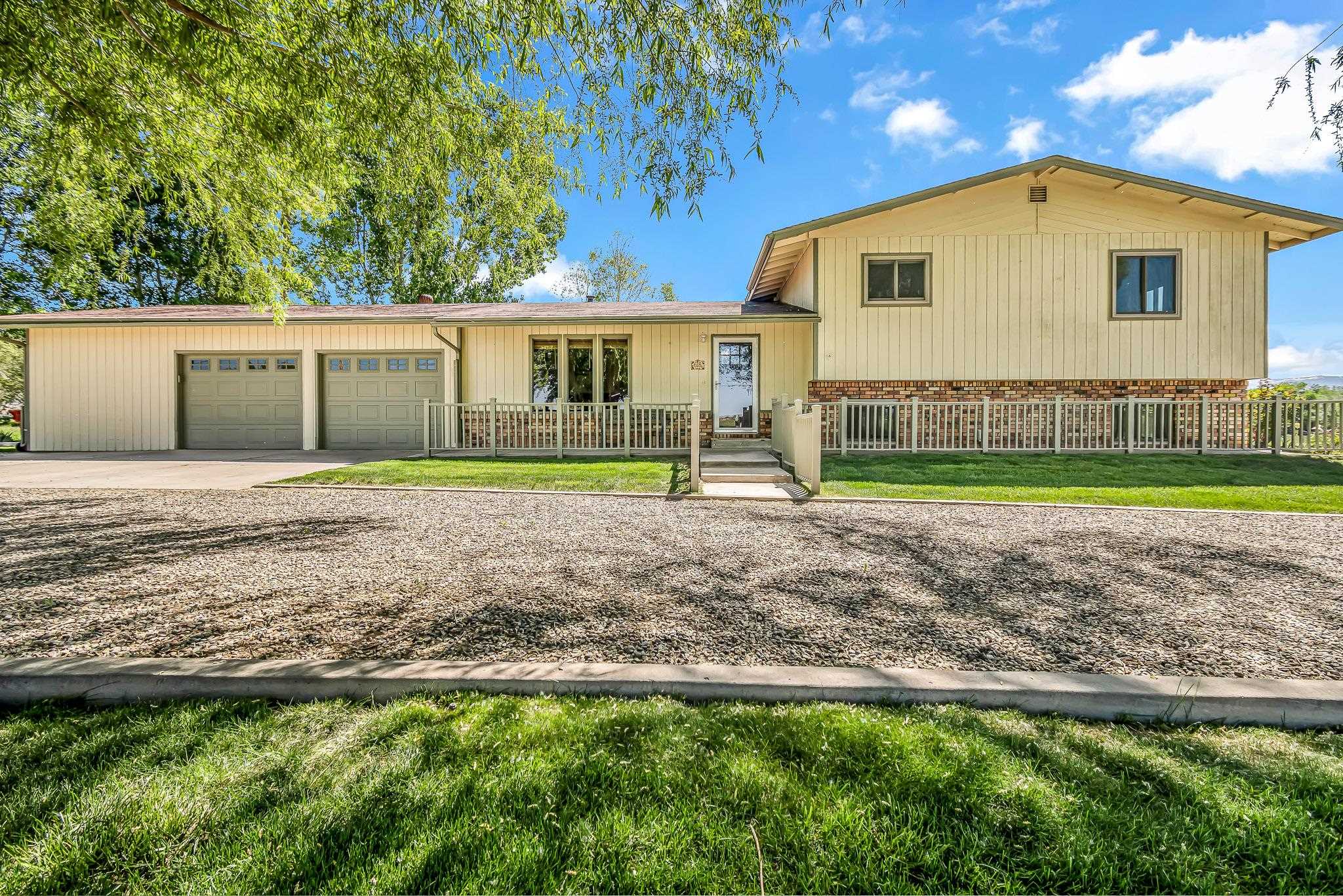 This 4-bedroom, 3.5 bathroom home is located on 9.57 acres in the heart of the Mesa County’s agricultural mecca near Palisade. The home is a 2304 sf, tri-level design that was built in 1977.  The kitchen has a window with unprecedented views of Grand Mesa. The kitchen’s cute farmstyle design includes double ovens, refrigerator, electric cook-top, dishwasher, wine fridge, garbage disposal and overhead exhaust fan above the cook-top and a large pantry area.  There are two separate living areas – one on the main floor as you enter the home and the second is in the lower part of the home. Large windows (new in 2022) are found throughout the home allowing for maximum natural light throughout. Flooring includes hardwood, carpet and tile.  There is an oversized 2 car garage attached to the home with a large storage area, ½ bath and office area. Outside is a 30’ X 50’ metal shed / garage / workshop with an RV hookup. A large 50’ long covered carport area alongside the exterior of the garage that works perfectly for either hay storage or as a covered area to park an RV.  The property was previously home to an Alpaca farm. Although the Alpaca farm is no longer in business, the property is still set up with an arena area. The panels have been removed so the new owner would need to replace the panels. Potable water is available to allow for fresh water to be delivered within the arena / corral area. There is no HOA and livestock are allowed on the property. A chicken coop that currently houses 5 hens is also included.  The grass hay that is grown on the property is a high quality variety that is perfect for alpacas and horses alike. The owners currently get 3 cuttings a year with an approximate yield of 550 – 600 bales. The bales are approximately 75lbs each and are selling this year for $9 each. The field has been maintained with proper fertilization and a neighbor processes (cuts, bales and stacks) the hay for each cutting.  There is gated pipe that is included in the purchase price.    The property has approximately 10 shares of Price Ditch water that is delivered to the property.  The cost for the irrigation water is assessed thru the annual property taxes. The property is zoned AFT.  It is not common to find a quality property of this size available anywhere in the Grand Valley area, let alone in such close proximity to Palisade.
