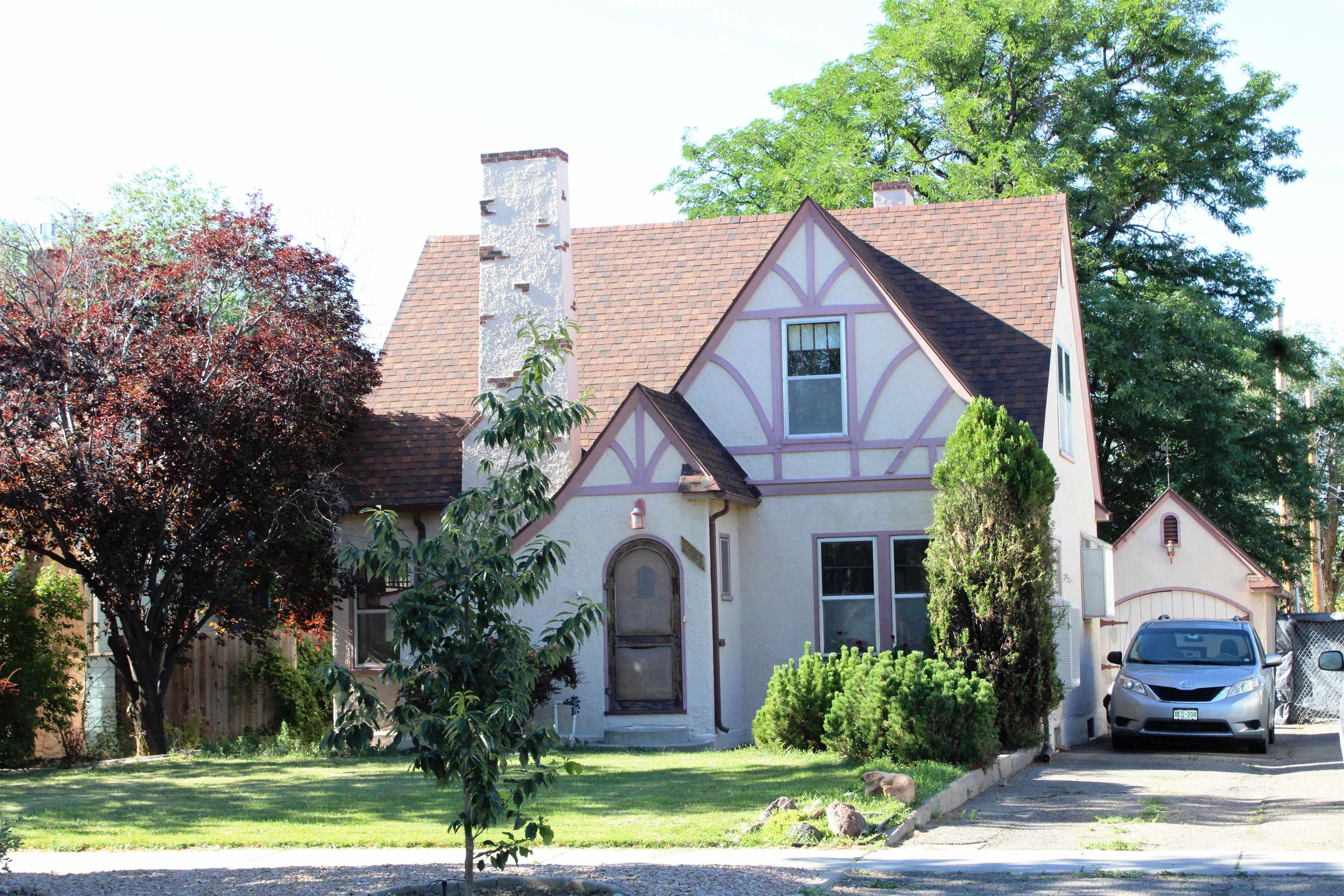 Attractive and unique stucco English Tudor-Style home within walking distance of Main Street Grand Junction. The downtown offers amazing restaurants and shopping plus Lincoln Park with its' stadiums, pool and 9-hole golf course is just 4 blocks north of property. Built in 1930, remodeled and updated, including new upstairs bath in 2017. Ground level master bedroom could also be mother-in-law apartment. Two bedrooms upstairs. Some original hardwood floors, cozy living room has wood burning fireplace. Landscaped front and back for beauty, shade, and summer outdoor enjoyment. Detached 1-car, architecture matches the house. Alley access for easy parking or RV storage. Property has the ability to add an ADU off the alley.  All information subject to change/error; buyer(s) to verify.