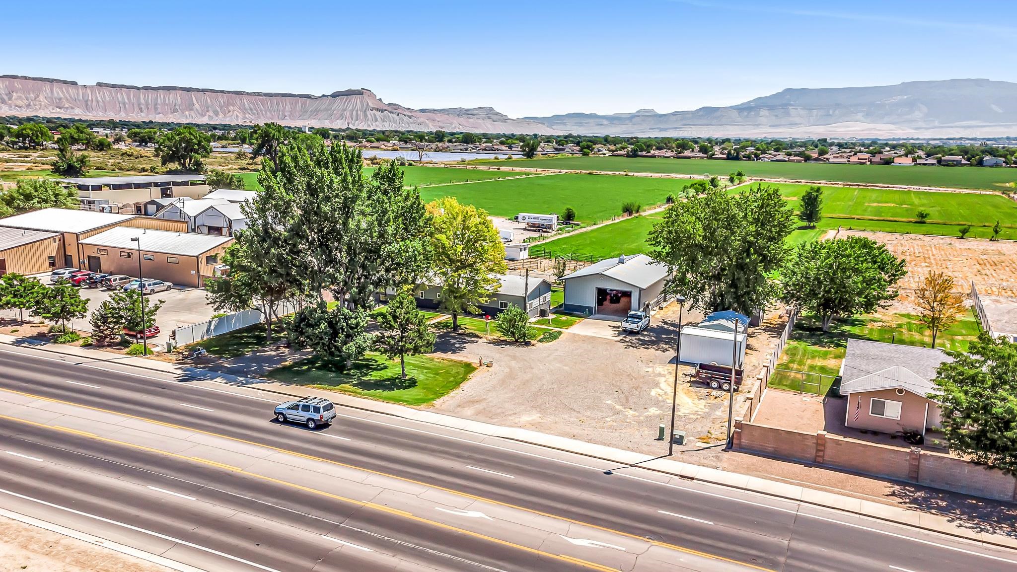 This property is in a Designated Opportunity Zone. Multi-use, 1968 ranch style home on 6.63 acres, has so much to offer, including 6 shares of water, a 30 X 50 shop with storage loft, air compressor with several hook-ups, insulated metal roof, 220 V power work benches! Also, 2 storage sheds, dog kennel, corral panels stay. 3 bedroom, plus office with pellet stove. 1 full bath with walk in tub and shower, and a 3/4 bath. Endless views, development possibilities, farming, business...you name it! Also, lots of updates - list is in MLS with disclosures.