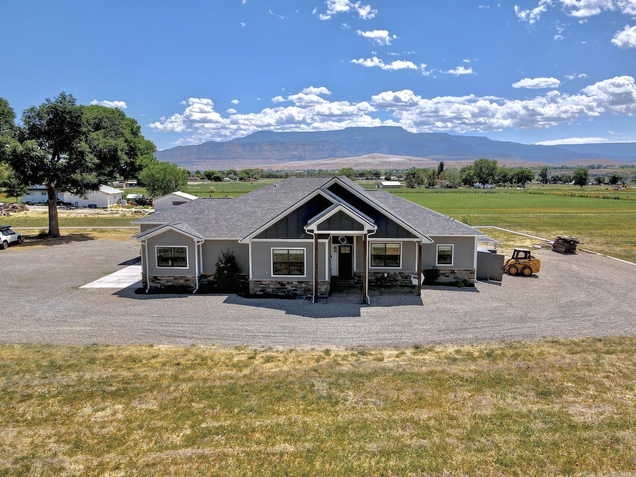 This stunning property of nearly 4 acres has outstanding views of the Grand Mesa and Mount Garfield. Offering a piece of Colorado farm country with the luxury of a one of a kind home. You will enjoy covered outdoor seating areas for sunrises or sunsets. Whether drinking coffee or sipping wine, this is the place you want to be every morning and every night.  As you walk into this gorgeous open concept home, you're met with views of the Grand Mesa that stream right in through the large picturesque living room windows. With a large dining room to fit all of your family and friends, as well as a meticulously designed dream kitchen, with beautiful custom made chiseled edge counter tops. Tucked away from the main living area, you will find your master suite, including an exceptional 5 piece ensuite bathroom, including the most beautiful finishes. Across the home are two sizable bedrooms each with walk-in closets and adjoined by a unique Jack and Jill layout.  Just a short 10 minute drive down the road past fruit orchards and the cutest farm country around, you'll find Palisade Colorado. Offering some of the best peaches and wine in the country This home is a can't miss opportunity of bliss and relaxation.  Additional remarks: No HOA. Kitchen refrigerator, stove, microwave, dishwasher, washer and dryer included. Kitchen counter tops are chiseled edge granite. Exterior walls are 2x6 with hardie concrete siding. Home is wired for cat 5 hard wired ethernet.
