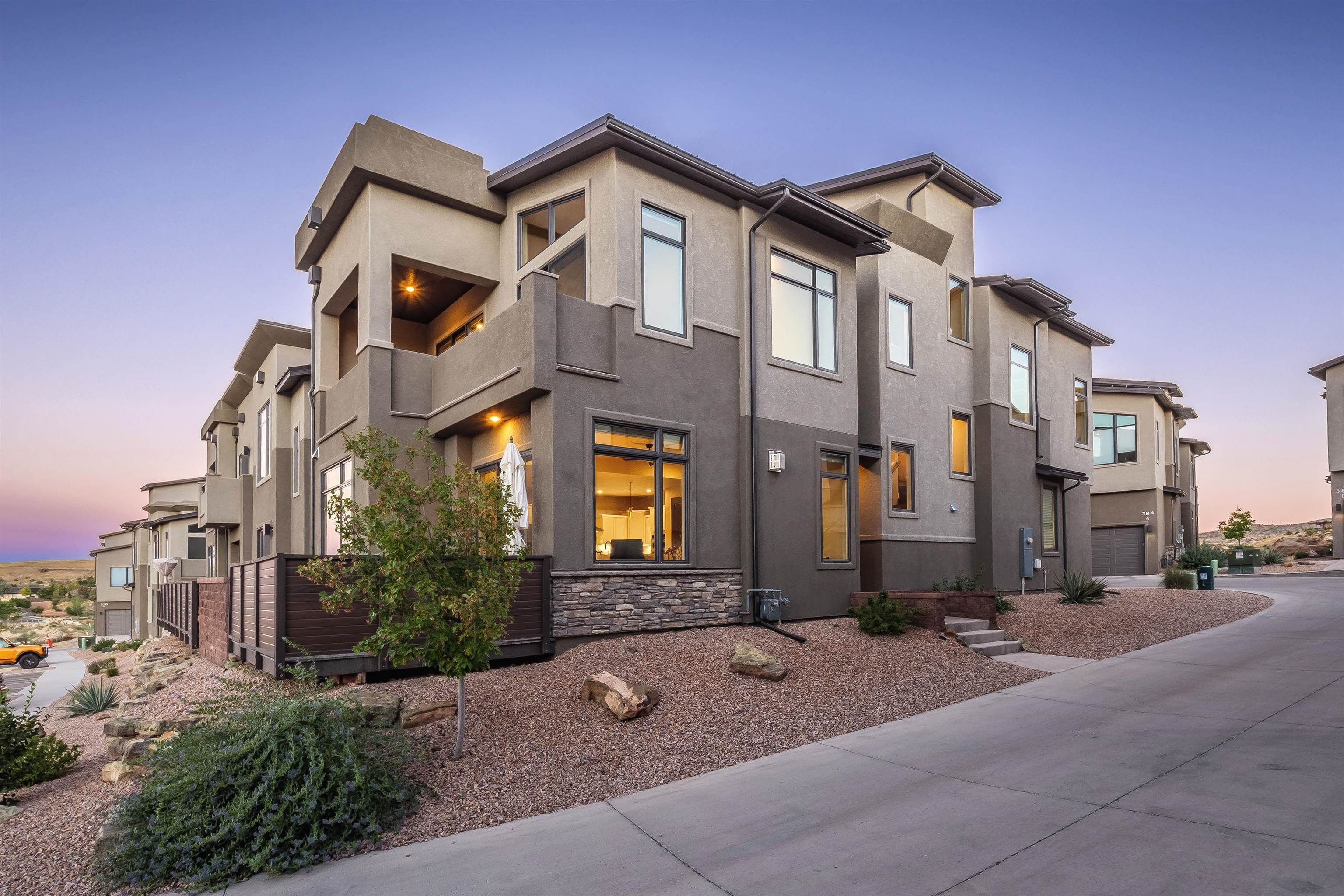 Introducing an opulent haven nestled in Redlands Mesa, this luxury townhome redefines urban living.  Impeccably designed by a recognized Lake Tahoe interior designer, every detail of this property was custom selected – from finishes, flooring, lighting, and accoutrements; this residence exemplifies sophistication and comfort.  The spacious open-concept living area boasts soaring ceilings and expansive windows that bathe the space in natural light, creating an inviting ambiance.  The gourmet kitchen is a culinary masterpiece, featuring Kitchenaid appliances, custom cabinetry, and a generous island with seating.  It's a chef's dream, ideal for everyday cooking and entertaining guests.   Adjacent to the main living area is a wonderful flex/4th bedroom with a custom barn door, making for a perfect media center, guest overflow space, or working remotely.  Upstairs awaits a spacious floor plan with a large primary suite, including a spacious lounge area, a private balcony, BIG walk-in closet with a custom closet design that rivals a boutique hotel, and a stunning en-suite bathroom.  Also located upstairs, enjoy the efficient laundry room with leading appliances and custom cabinetry.  All bedrooms have an accompanying en-suite bathroom.  The rooftop terrace offers a serene escape for those seeking a blend of indoor and outdoor living.  Whether hosting al fresco dinners or simply enjoying the sunsets highlighting stunning Monument and Bookcliff views, this rooftop escape provides an amazing setting.  Additional amenities include a dedicated home office/ possible 4th bedroom and a spacious 2 car garage.  Every aspect of this townhome has been thoughtfully curated to elevate your lifestyle.  You are just a stone's throw away from Redlands Mesa Golf Course, designed by award-winning golf architect Jim Engh".  This townhome is an end unit and provides plenty of privacy.  Located in the prestigious Redlands neighborhood, enjoy beautiful hiking, join the Redland Mesa Club, and appreciate the easy access to amenities, restaurants, and services.  This luxury townhome is not just a residence; it's a statement of refined living at its finest, where every detail exudes an unmatched level of sophistication and comfort.