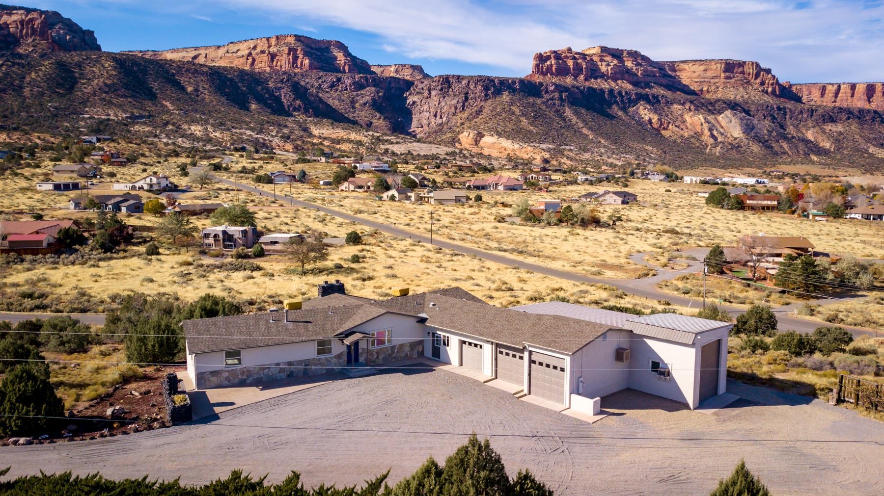 Views! Expansive windows in the living room and an open balcony frame the Colorado National Monument to the south. West windows highlight additional majestic views, from the front patio enjoy the picturesque views of the Bookcliffs and Grand Mesa. This large, totally refreshed home features new Stucco exterior finish, new appliances, quartz counter tops in kitchen, and new LVT flooring throughout. No HOA to limit your imagination. Generous 2 acre lot with potential for split. 4 finished garages including 16 x 51 RV unit. Modern touches abound throughout. For the recreational enthusiast mountain biking, hiking, golf and walking trails are within minutes of your door. Spacious parking and refreshed gravel allow for all your toys!.