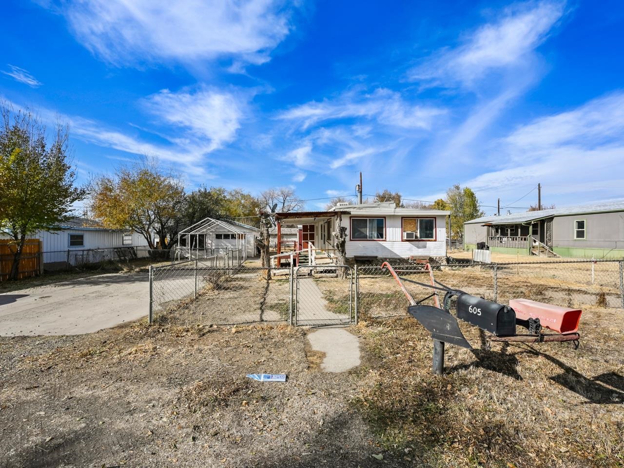 Welcome to this fantastic opportunity in the heart of Grand Junction! This property is a spacious mobile home lot with a permitted shop/garage, offering endless possibilities for your dream setup. Located in the northeast part of town, enjoy proximity to plenty of amenities and conveniences. A fully permitted shop that runs with the land and is equipped with an array of tools is already in place and ready to facilitate your projects and hobbies. While not purged to the land, the existing trailer is included in the sale. It would require significant renovation or replacement, but offer you the opportunity to create or choose your own ideal home, tailored to your tastes and needs. With a fenced lot, ample parking, and abundant storage space, this property offers incredible potential to create your envisioned space tailored to your preferences. This opportunity is ideal for those seeking a versatile property with the freedom to craft their ideal living space, taking advantage of the included shop/garage and the potential for a new home. Don't miss this chance to secure a mobile home lot with a permitted shop in Grand Junction. Contact us today to explore the possibilities this property offers. Please Note: The existing trailer is in suboptimal condition but presents an opportunity for renovation or replacement. Entering the main home may require precautionary measures due to a strong odor. A mask is recommended.