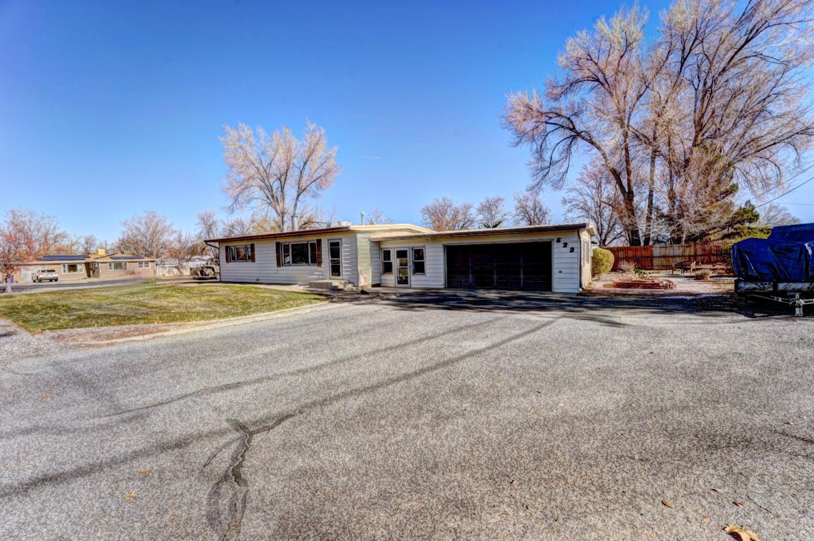 Nestled in the heart of Grand Junction on the Redlands! This mid-century Ranch-style property offers a spacious 3-bed, 2-bath layout with 2572 sq ft of total living space. The main level showcases original hardwood floors, a beautiful woodburning fireplace, updated kitchen and bathrooms, 2 bedrooms, and views of the National Monument! The fully finished egress basement means this home is made for comfortable living and entertaining. Downstairs you'll find an oversized 3rd bedroom, the family room with wood burning stove, and a huge 400 sq ft flex room. This home is perfectly situated on nearly a 1/3 of an acre across the street from Broadway Elementary. Enjoy the freedom of No HOA and ample RV parking. Embrace the convenience this home provides with easy access to local amenities, shopping, dining, while enjoying the best that western Colorado living has to offer. Schedule your showing today and make this haven yours!