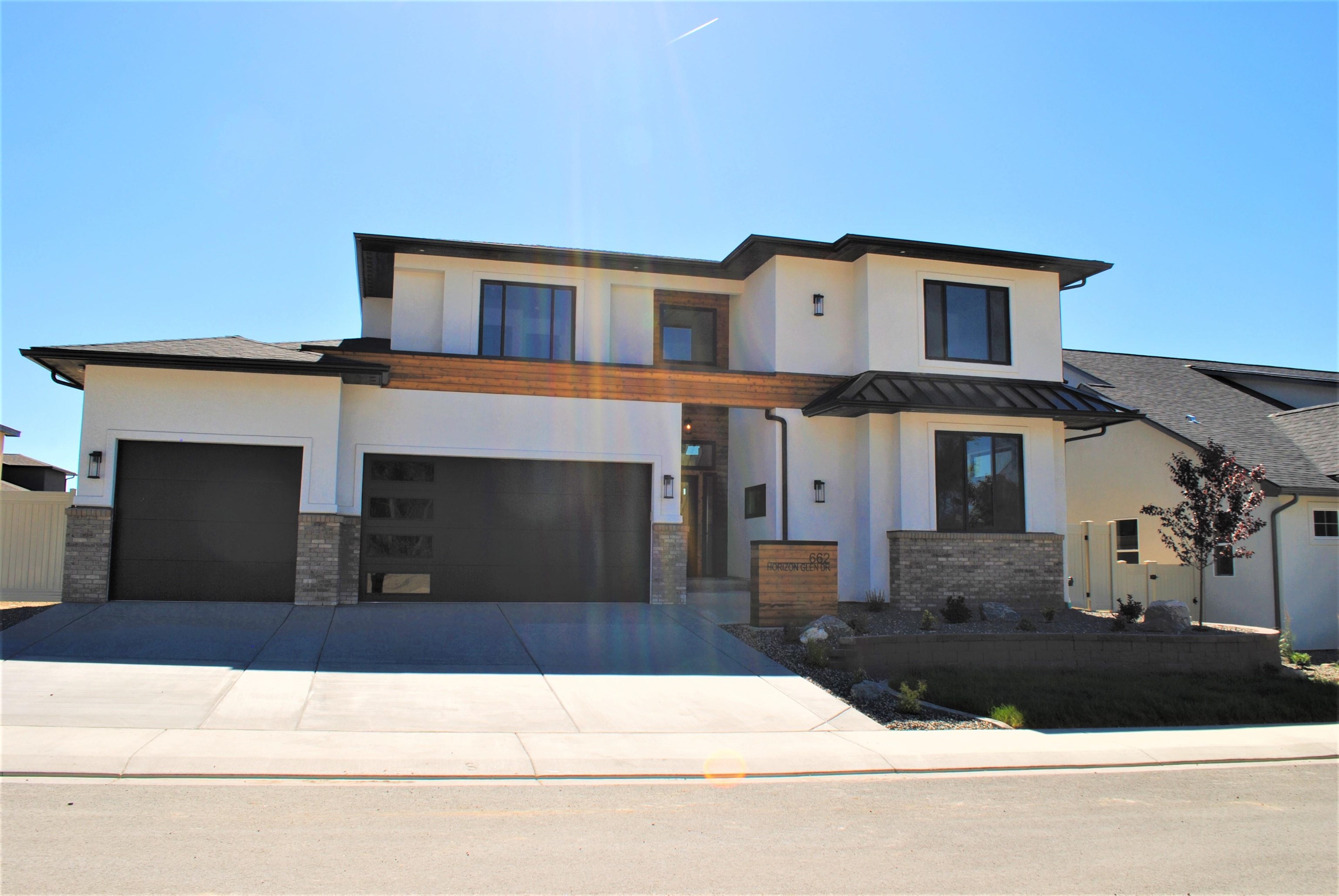 Stunning says it all. The finishes and builder upgrades make this home stand out, starting with the impressive deep front entrance with stained wood around the front door. The large open foyer leads to a bright living area and upper level staircase with wood steps and glass walls. Master suite is on the main level separated from the rest of the house by the impressive foyer area, with a bonus tech/office room. Beautiful efficient kitchen featuring upgraded Thor appliances, quartz counters, and a café style door to pantry and laundry room, plus powder bath all opens to the great room with floor to ceiling brick lineal gas fireplace. Engineered hardwood floors throughout the house except bedrooms. Master suite has a roll in shower with rain head, split vanities, stand alone tub, and walk in closet plus double barn doors. Upstairs is a full bath with double vanities and 2 bedrooms, plus family room perfect for additional gathering events. There are windows across the top on two walls capturing the amazing views of the Mesa and Mt Garfield. Front yard will be landscaped plus a 6' tall vinyl fence around the perimeter is included in the price.