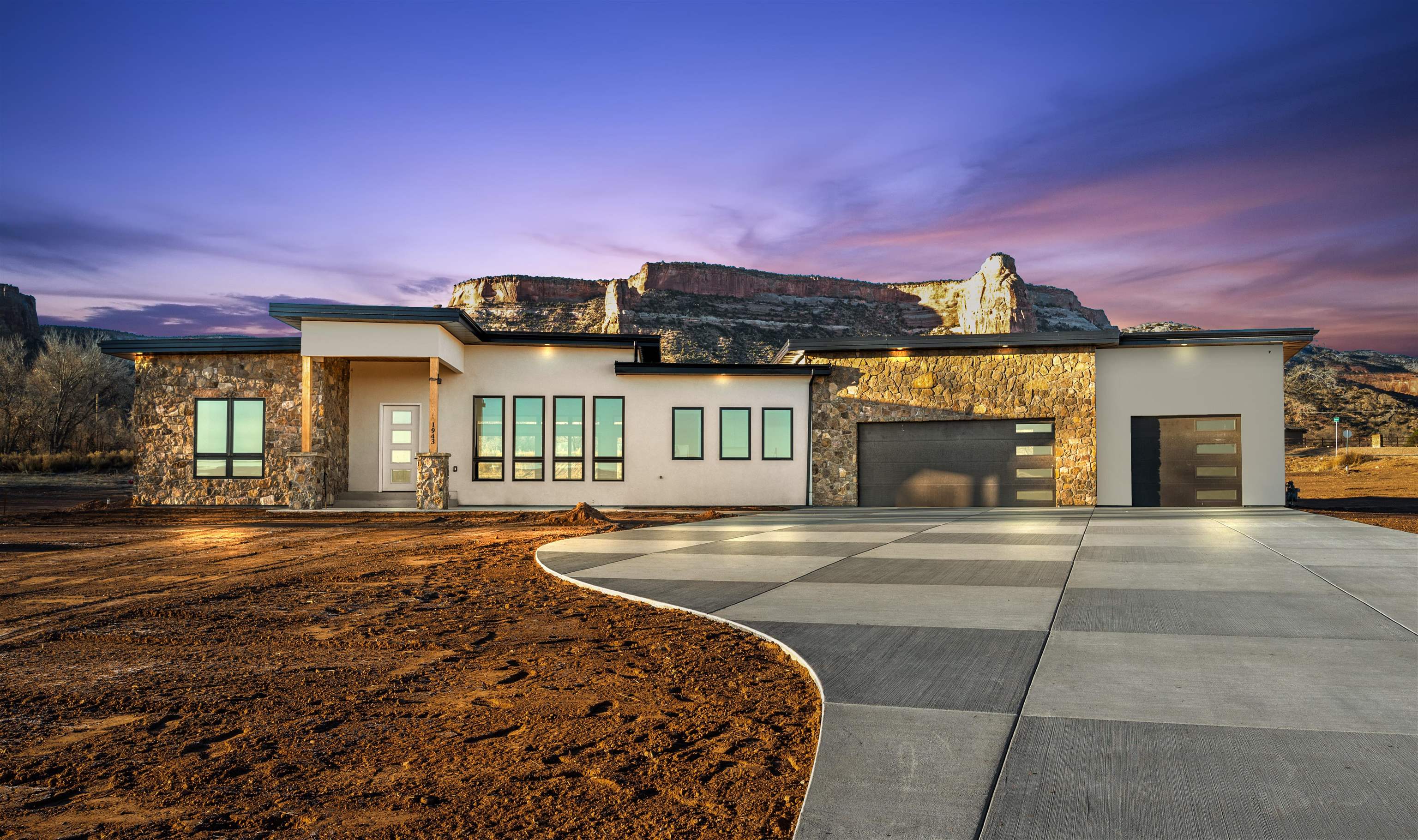 Nestled on nearly 2 acres of pristine land with breathtaking panoramic views of the Colorado National Monument, this modern Porter Homes built 3082-square-foot residence is a haven of luxury and comfort. This residence features 3 bedrooms each unique in their own way. The primary is a sanctuary with a 5-piece bathroom and a large walk-in closet. The Jr primary features a luxurious full bathroom attached with its own access to the outside. The kitchen and its expansive pantry make it a chefs delight. Ideal for both entertaining and everyday living, the open layout enhances the sense of space and light. The office has a 2-way fireplace peaking into the living room enhancing its ambiance. Practicality meets luxury in the large laundry room, complete with a sink, providing functionality and ease in daily tasks. The property boasts a huge garage, offering ample space for multiple vehicles and additional storage along with a pet wash station! The covered back patio invites you for the experience of enjoying the views all with an easy access to the house to help entertain.