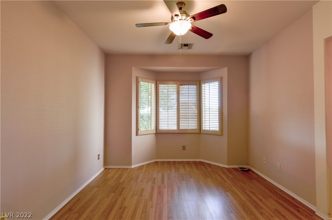 Photo #14 Primary bedroom features shutters and ceiling fan.