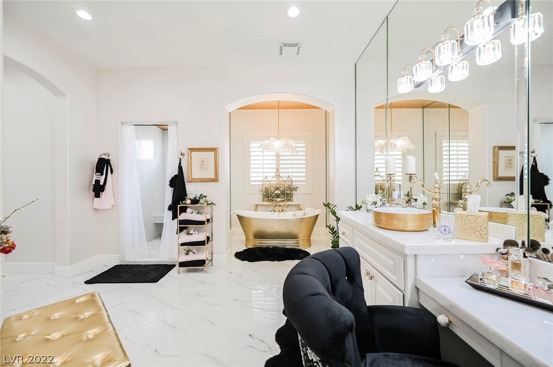 The Golden Touches on the Tub and Sinks add Elegance to the Oversized Room.