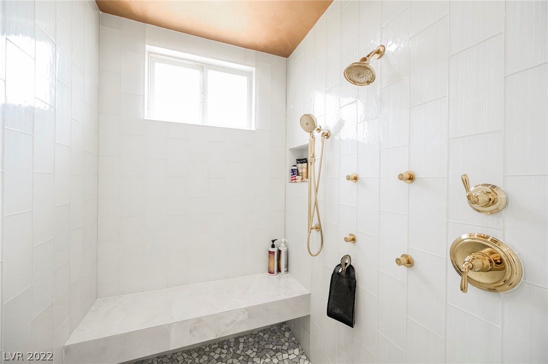  The Large Bathroom has a Soaking Tub with Shower Attachment that Sits Underneath a one of a kind feathered Lighting Fixture.