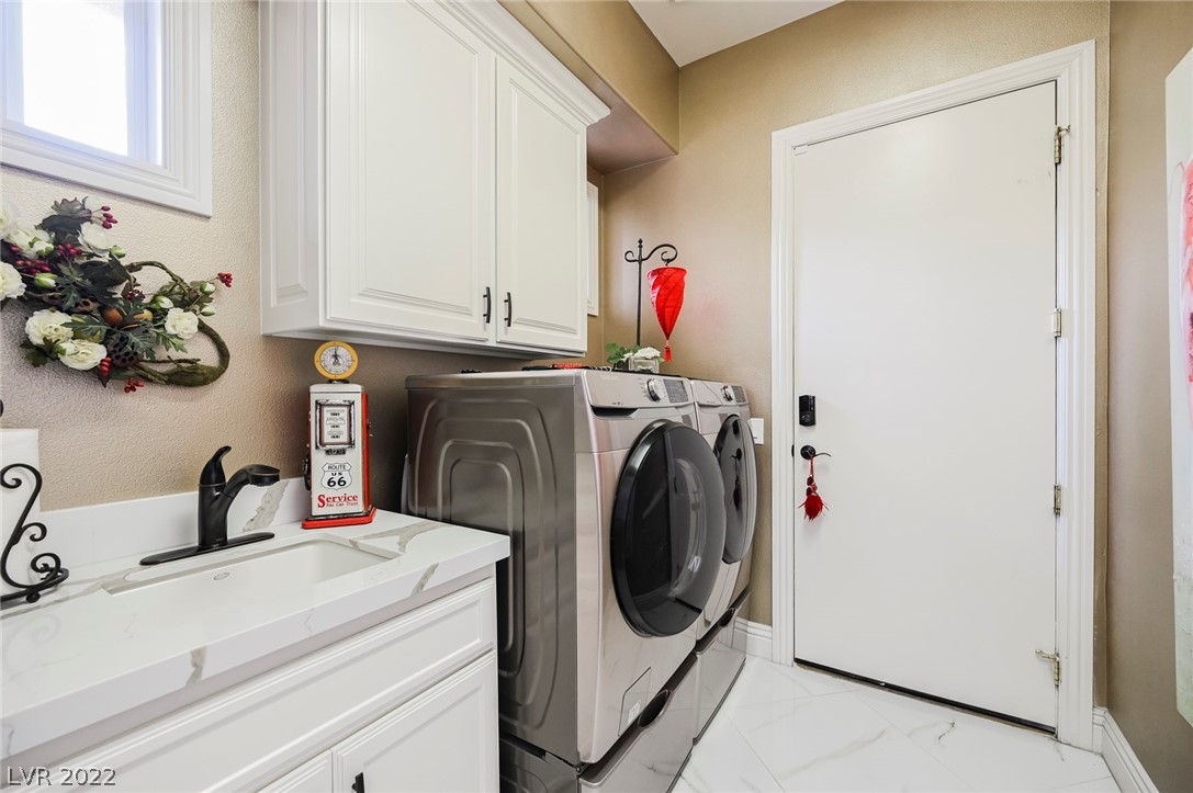 Full Laundry Room With White Cabinets & Sink.